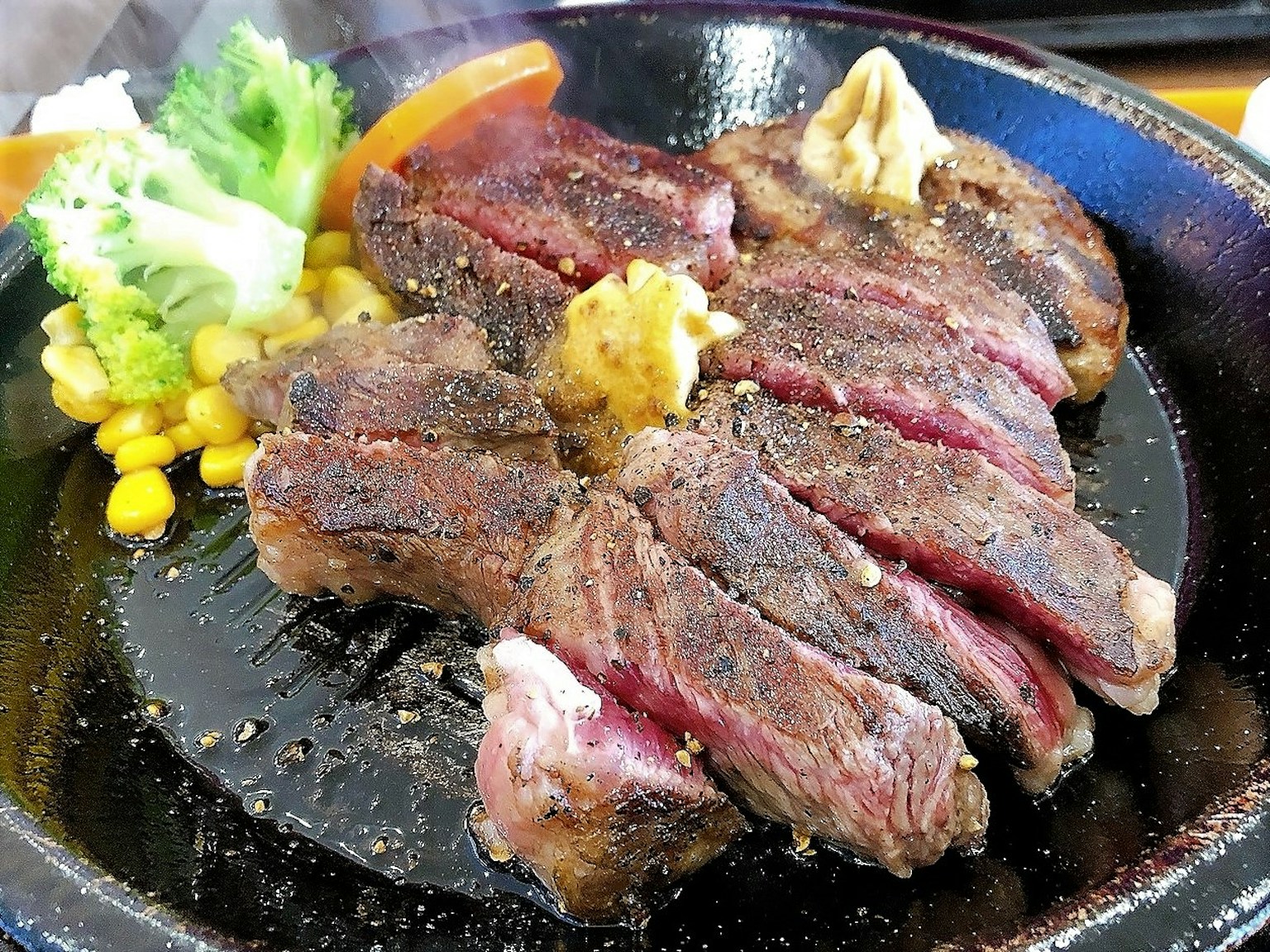热锅上盛着多汁牛排和蔬菜