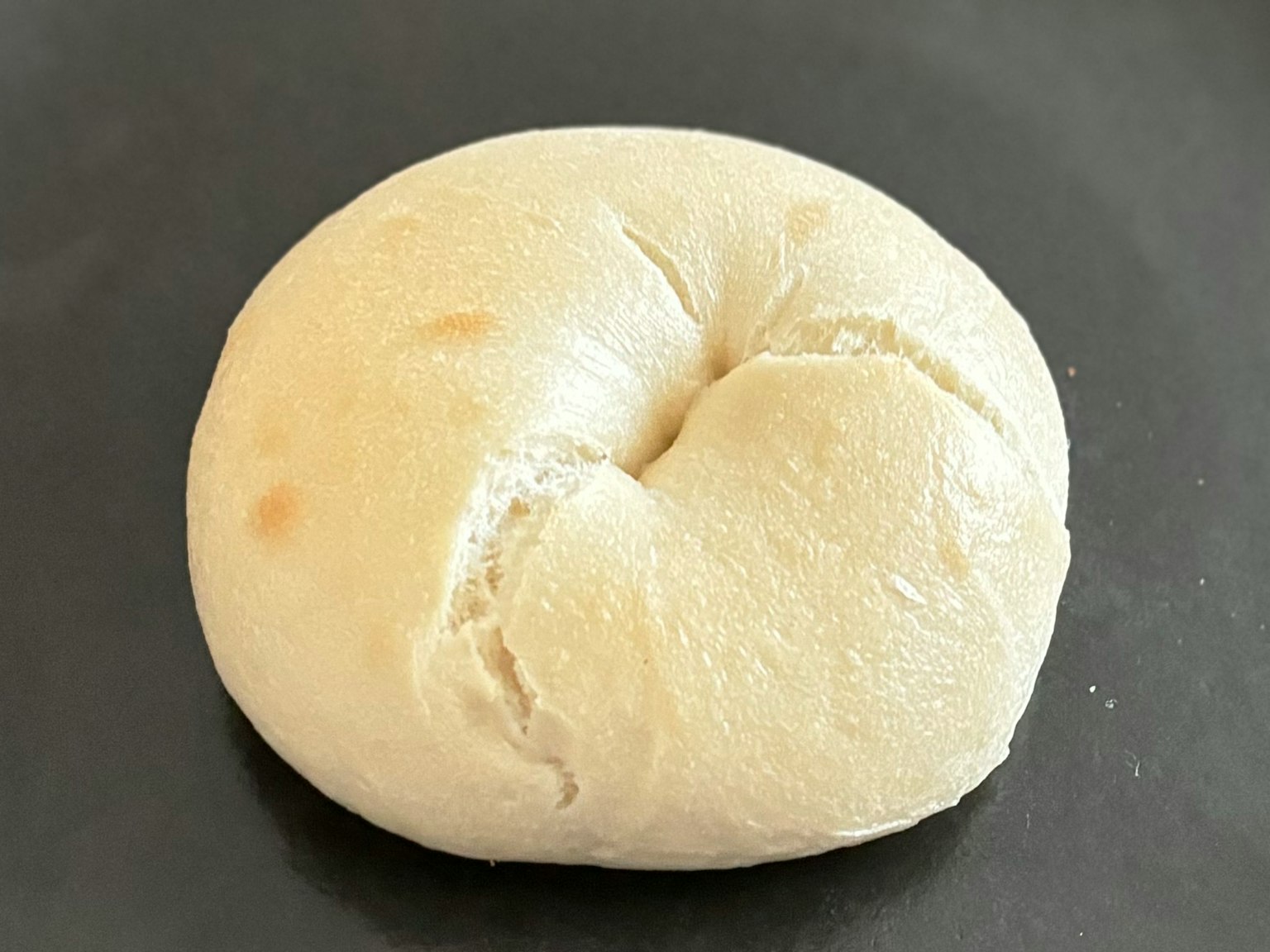 放在黑色盘子上的圆形白面包