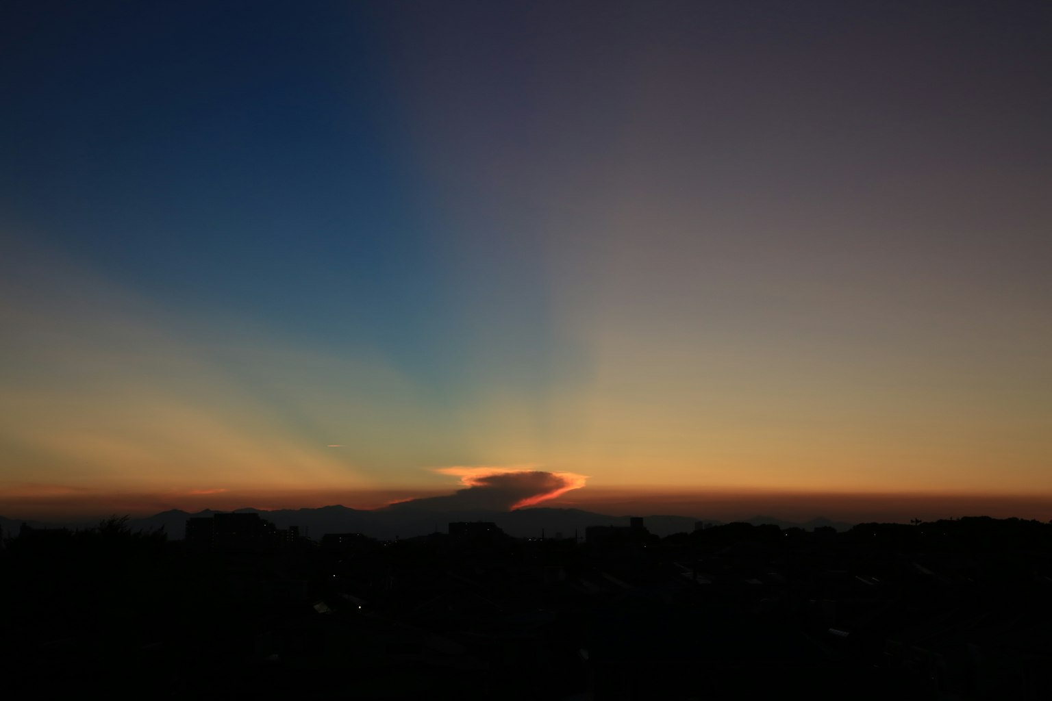 Silhouette di nuvole tra cielo blu e tramonto arancione