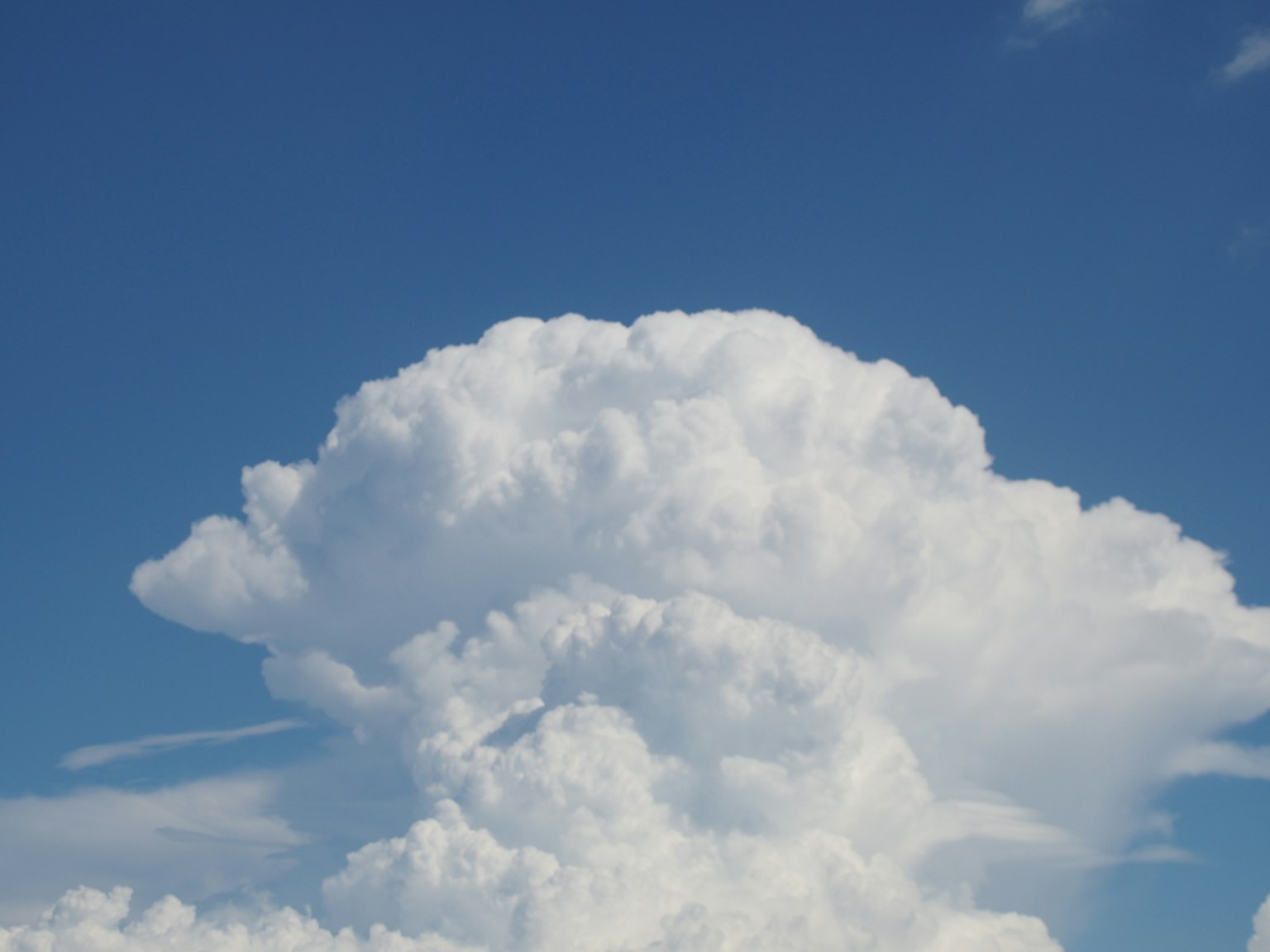 Un gros nuage blanc duveteux sur un ciel bleu clair