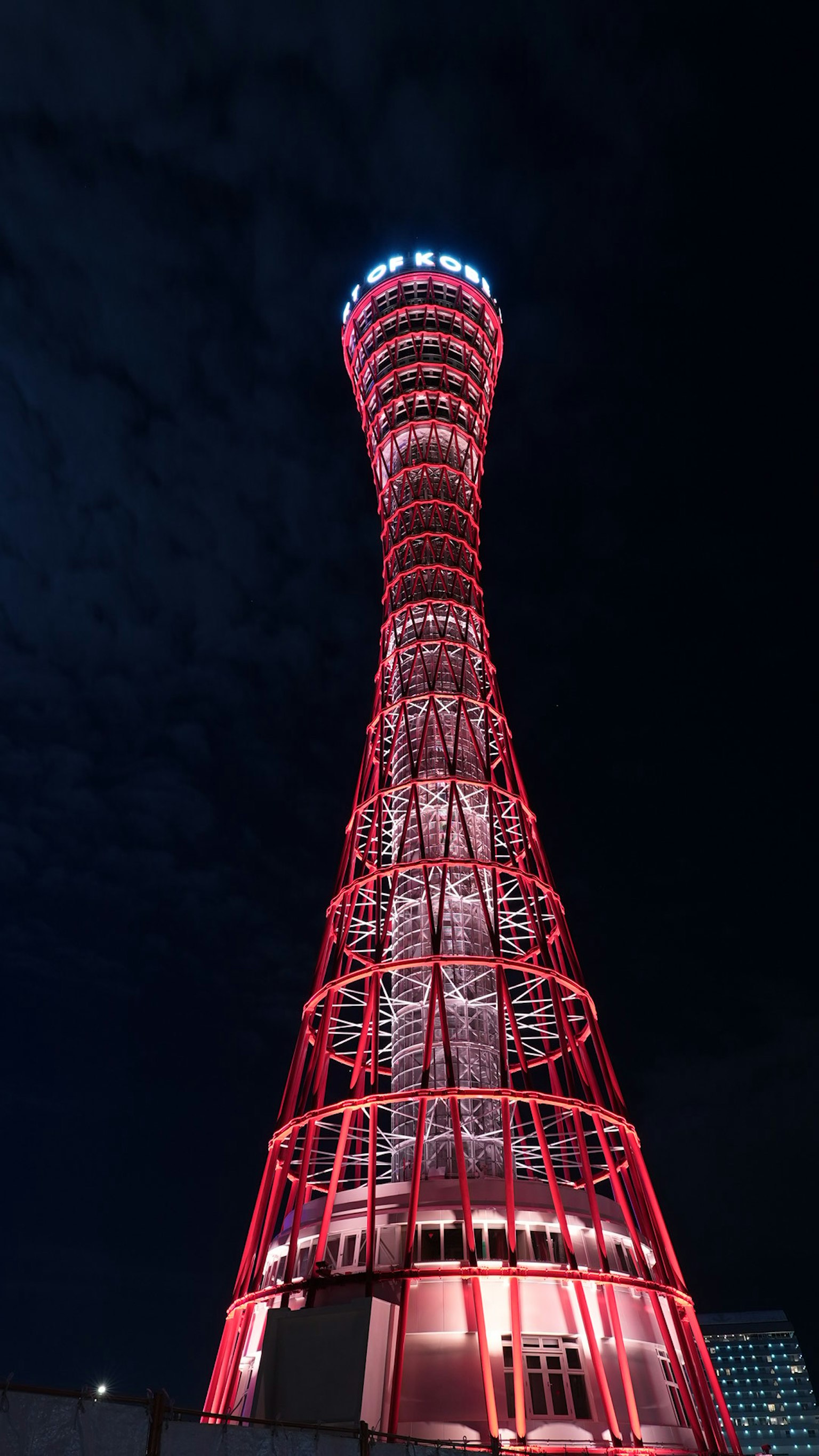 Tour de Kobe la nuit illuminée par des lumières rouges mettant en valeur sa belle structure