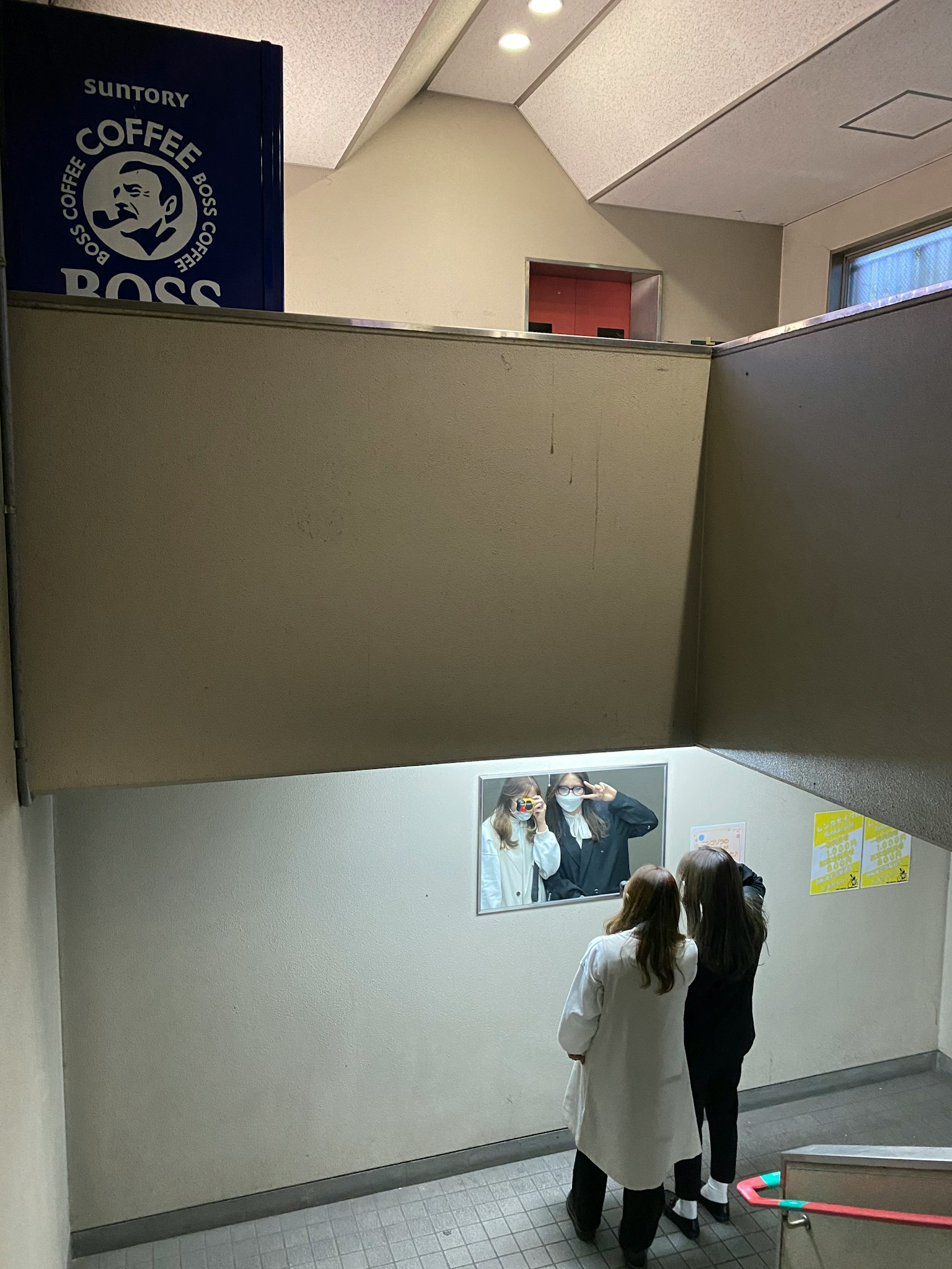 階段を下りる二人の女性とコーヒーショップの看板