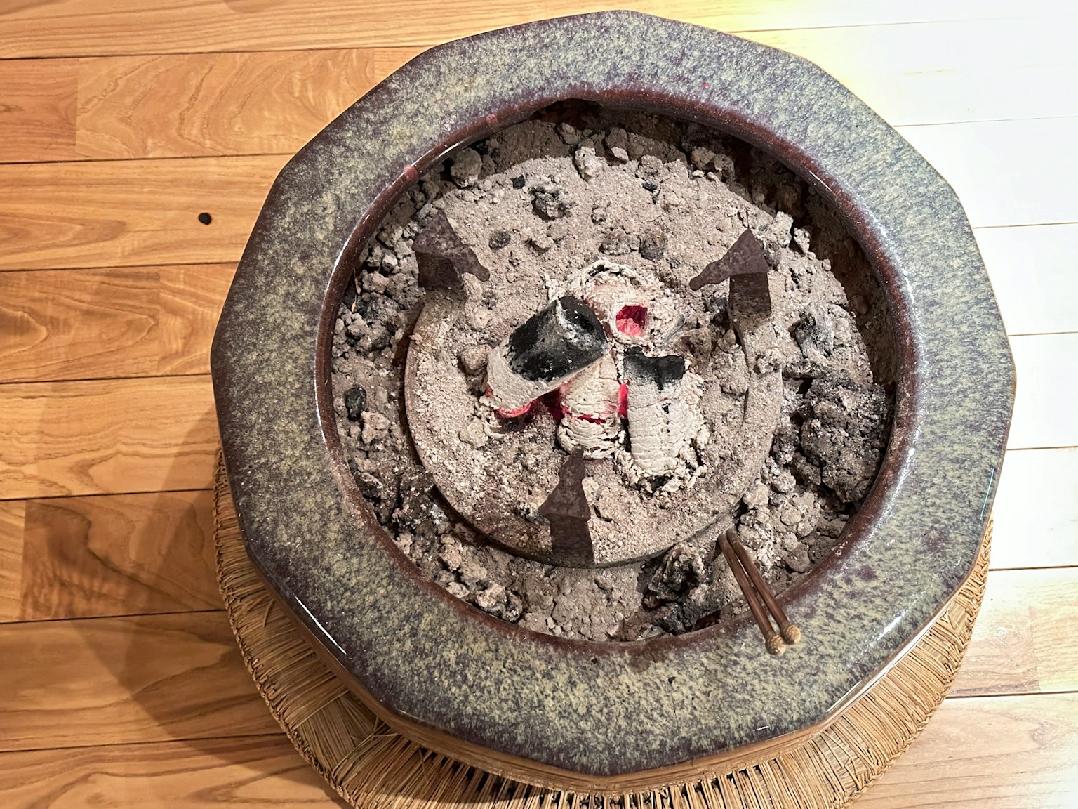 装满灰烬的陶瓷火锅在木地板上