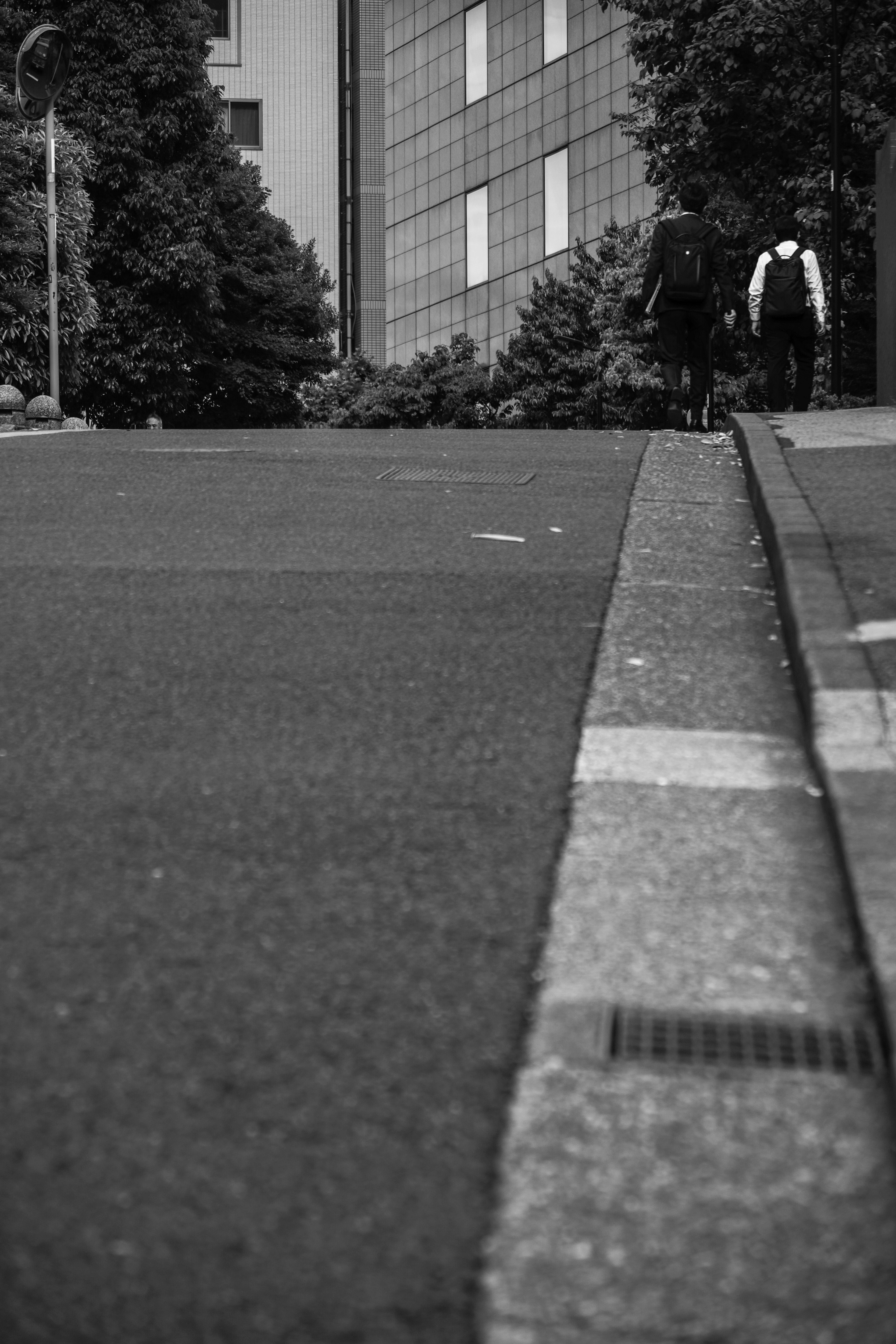 急勾配の坂道を歩く人々のある都心の街並み