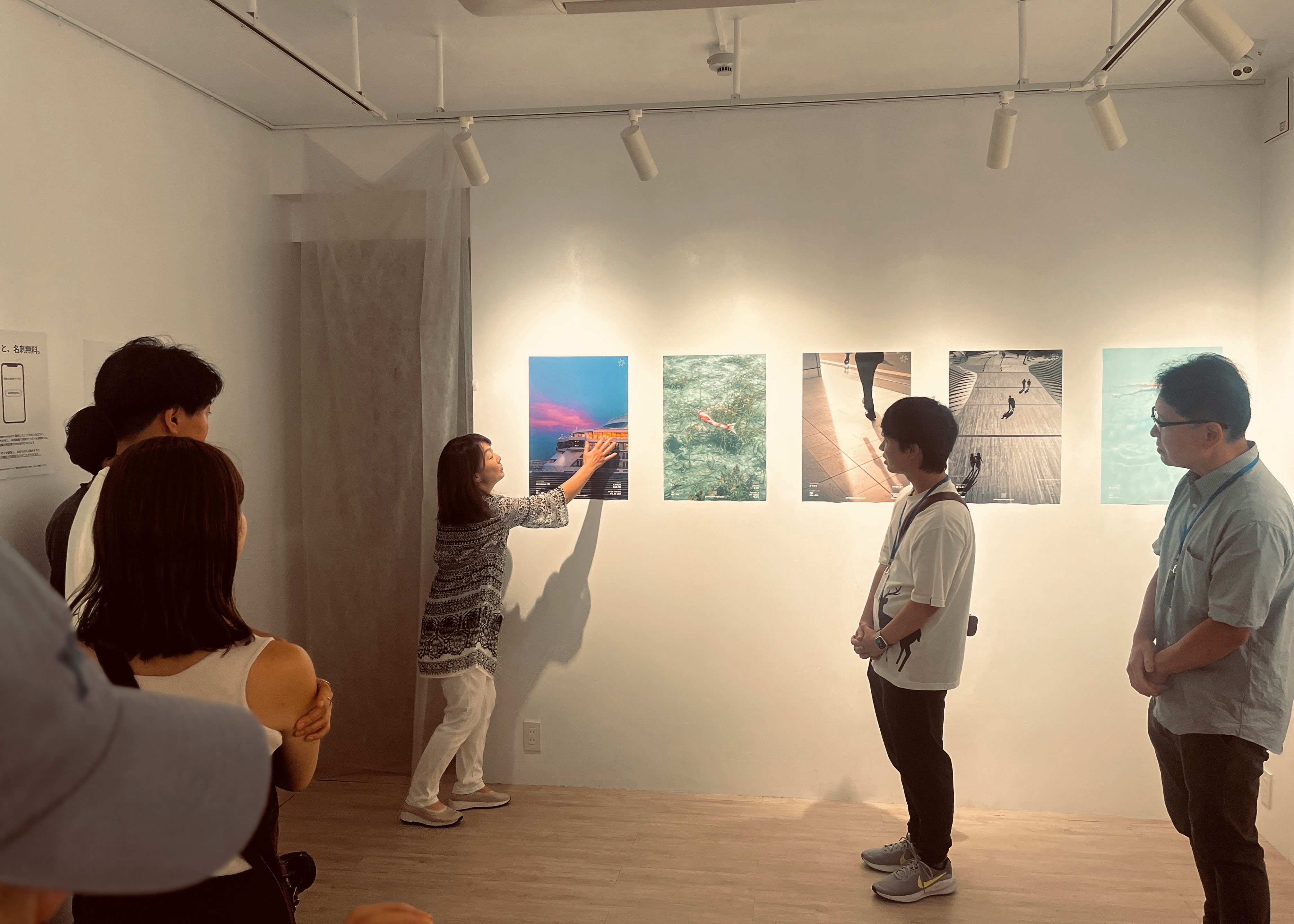 展示室で絵画を鑑賞する人々のあるギャラリー空間