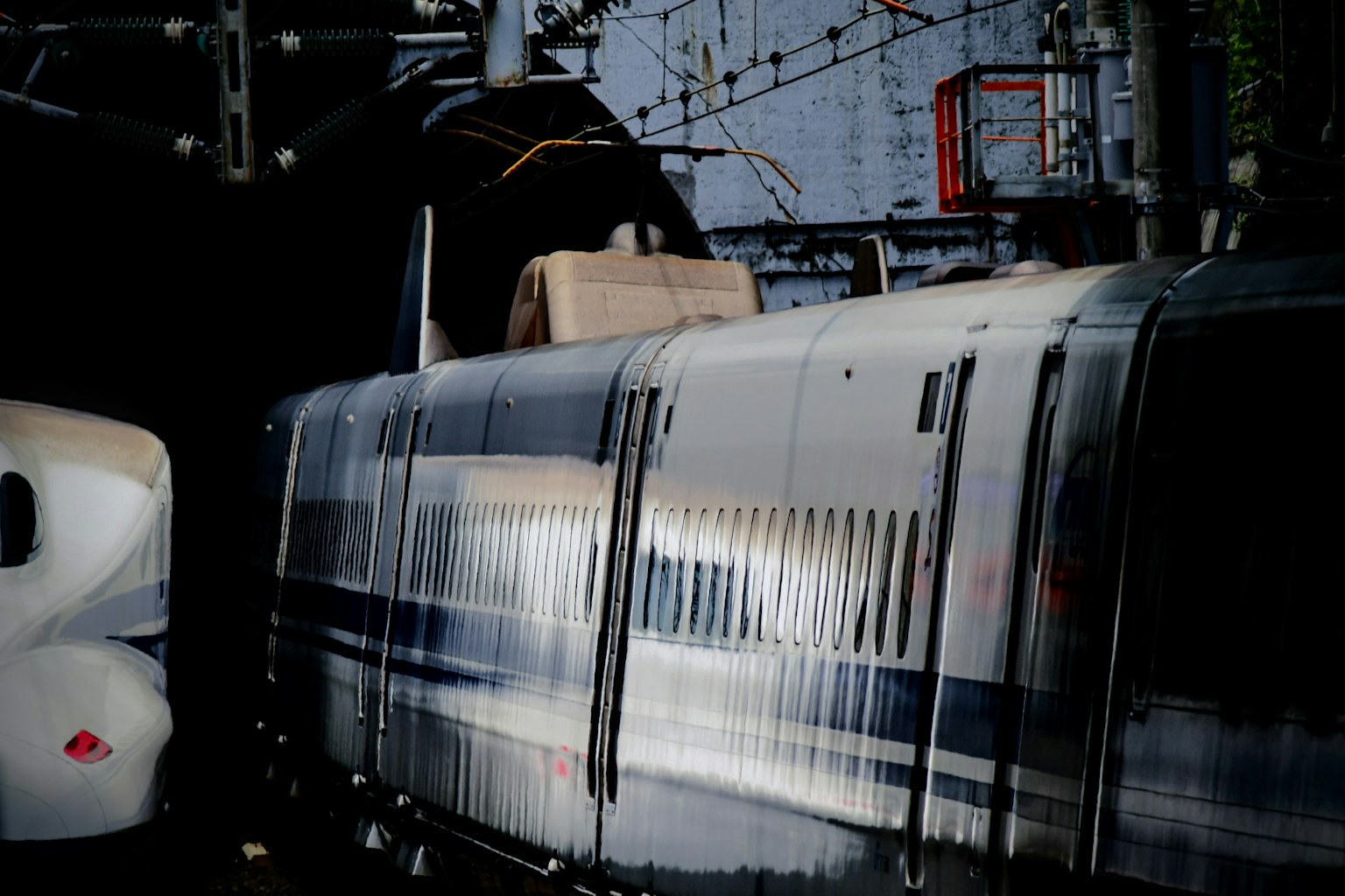 Treno ad alta velocità in stazione con superfici riflettenti