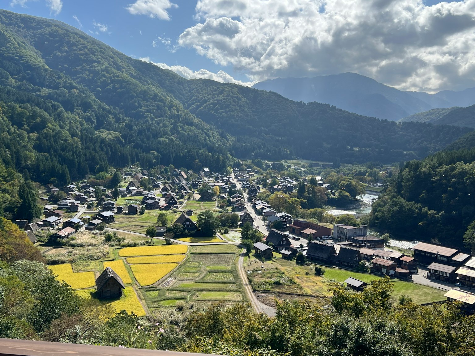 Pemandangan desa tradisional dikelilingi pegunungan dengan sawah