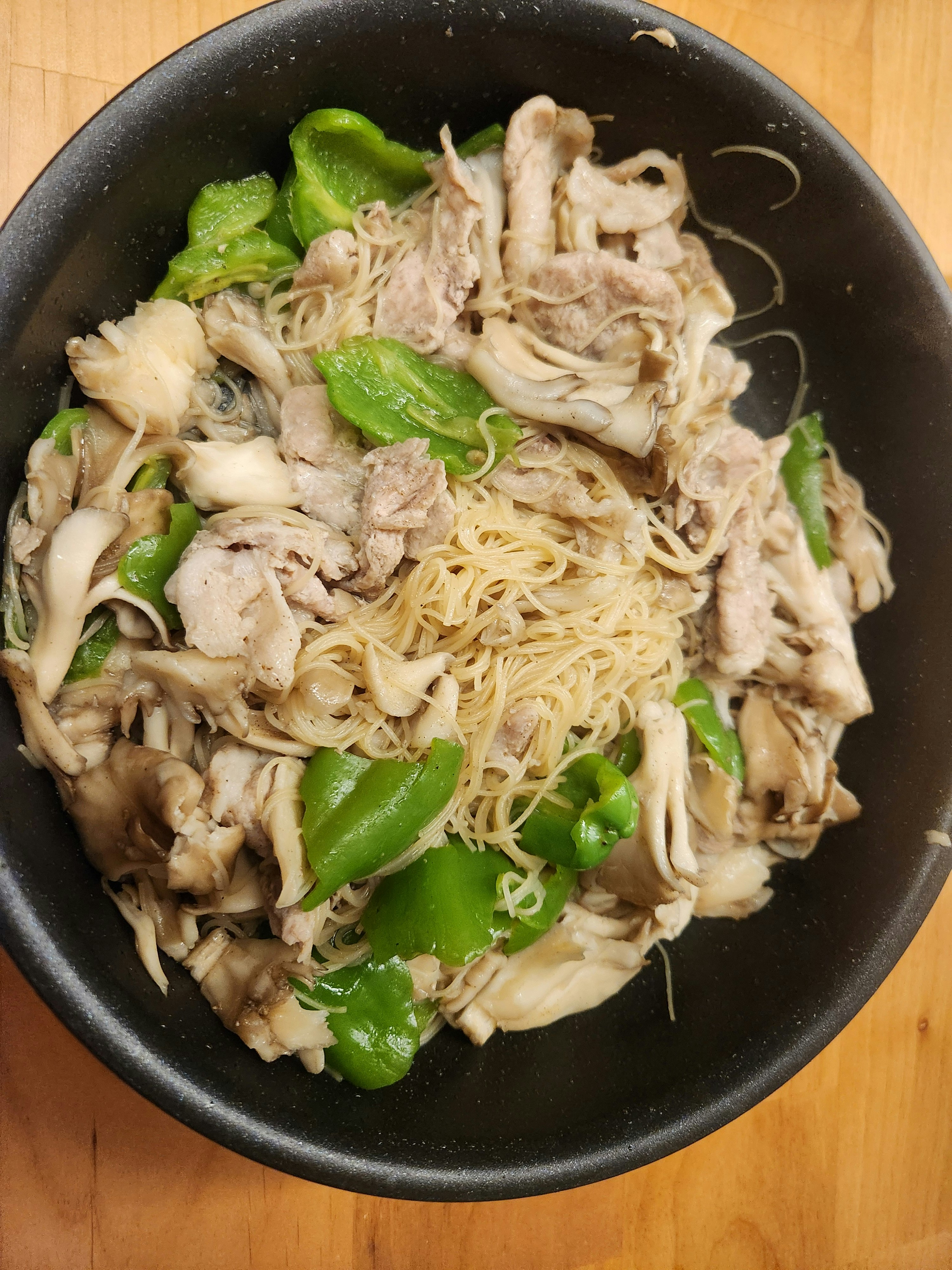 黑色碗里的蘑菇和青菜拌面