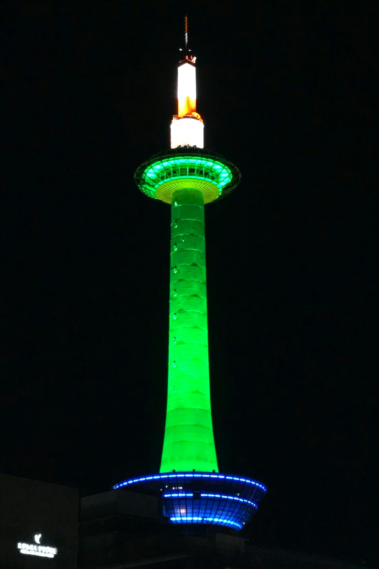 Torre di Kyoto illuminata con luci verdi e blu di notte