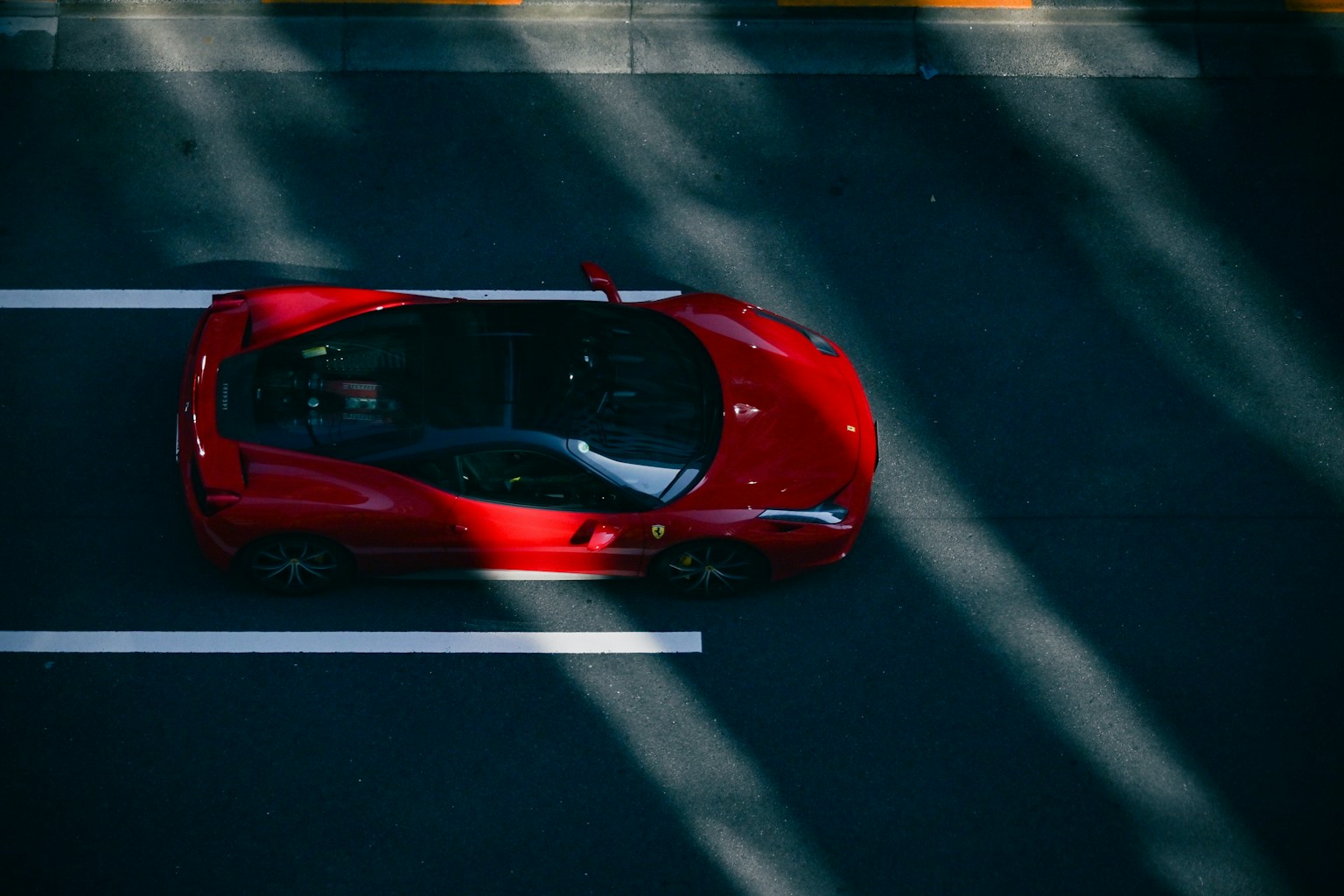 Mobil sport merah melaju di jalan dari sudut pandang atas