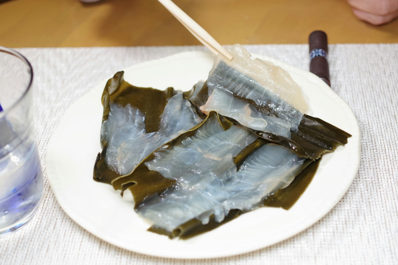 盤子上的透明海藻，筷子夾著一片