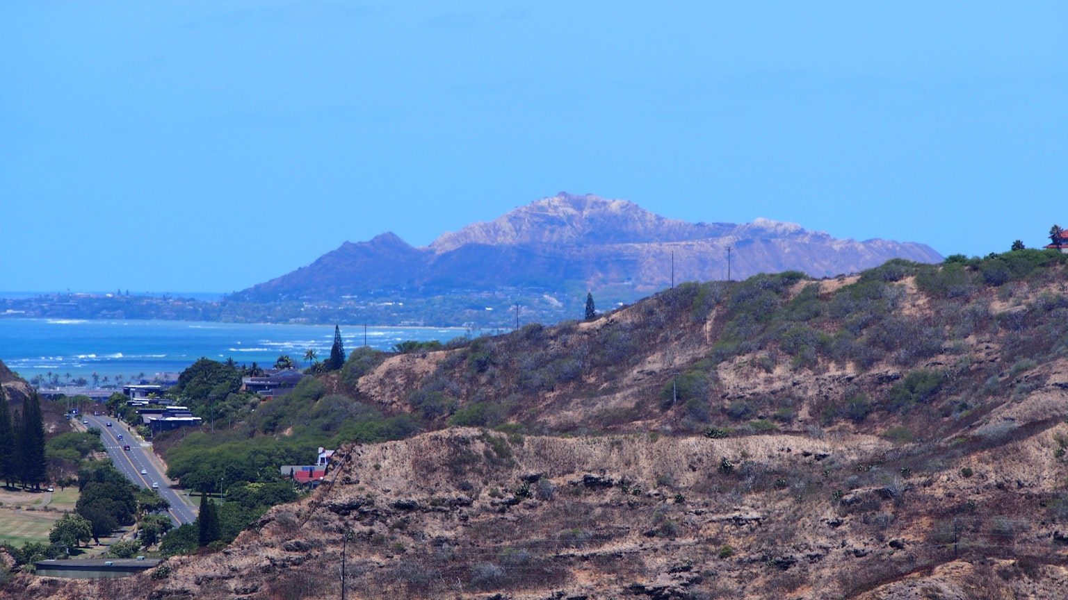 Vue panoramique sur l'océan et les montagnes sous un ciel bleu avec Diamond Head au loin