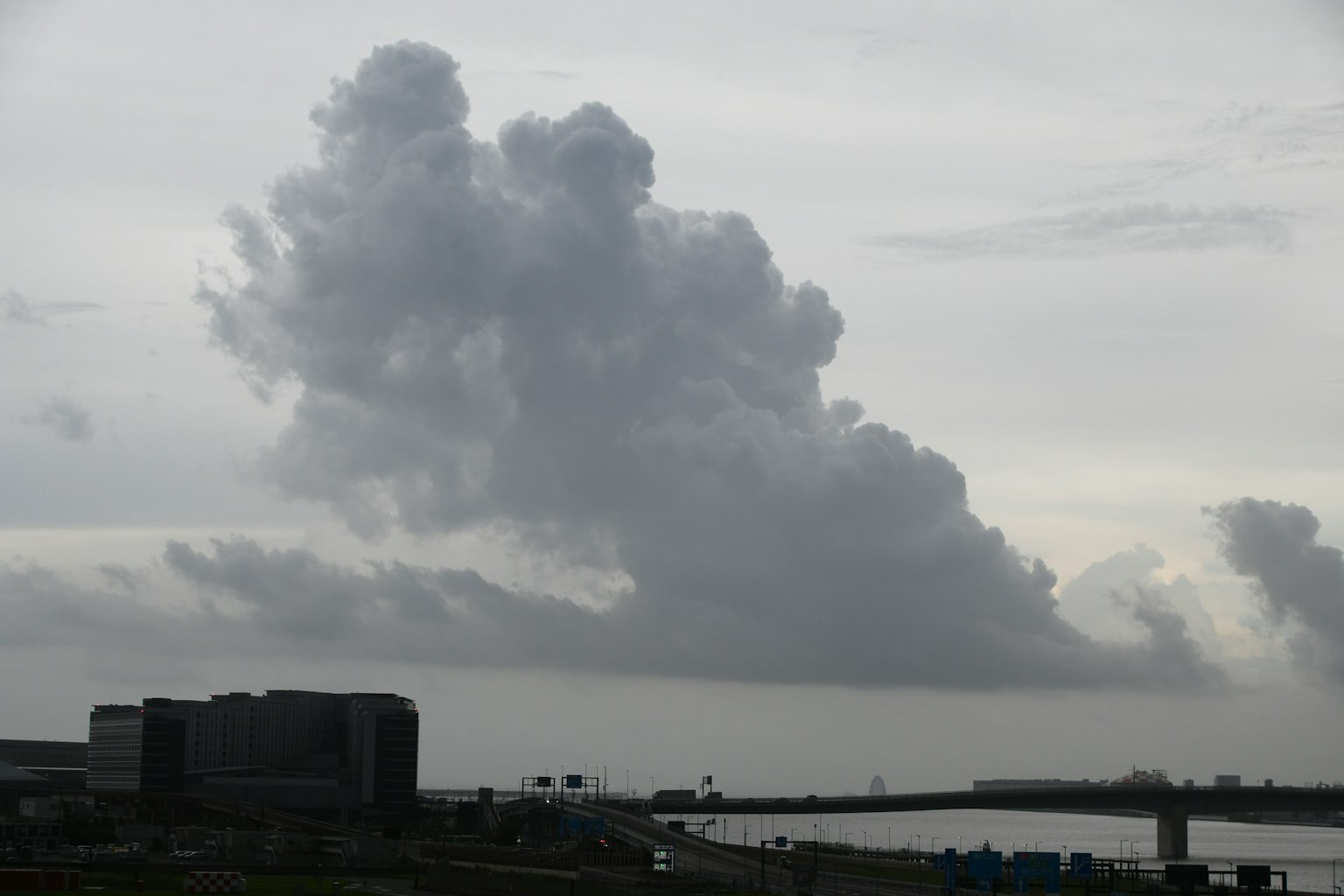 Ciel gris avec de gros nuages au-dessus d'un paysage riverain