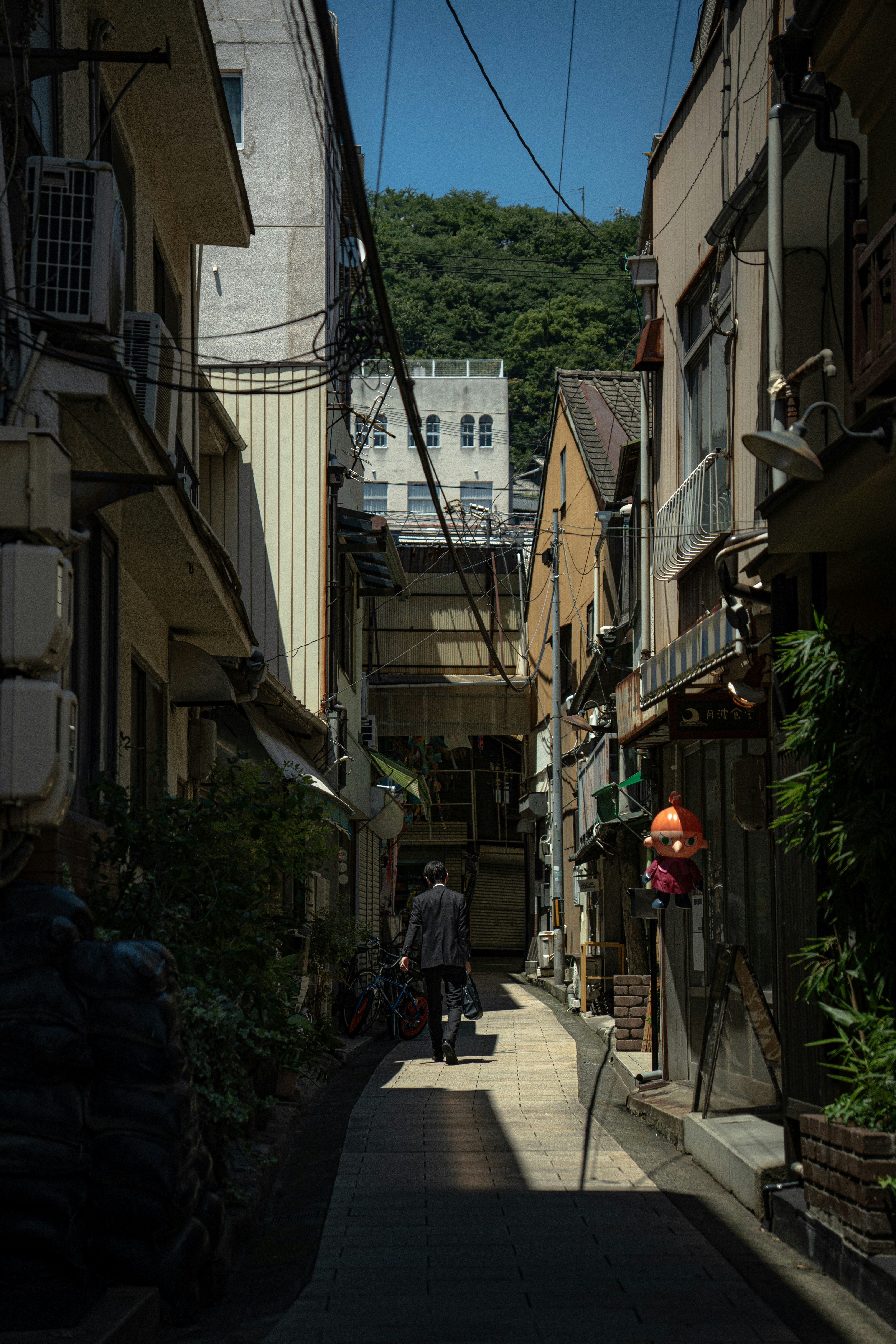 路地の両側に並ぶ建物と電線のある街並み