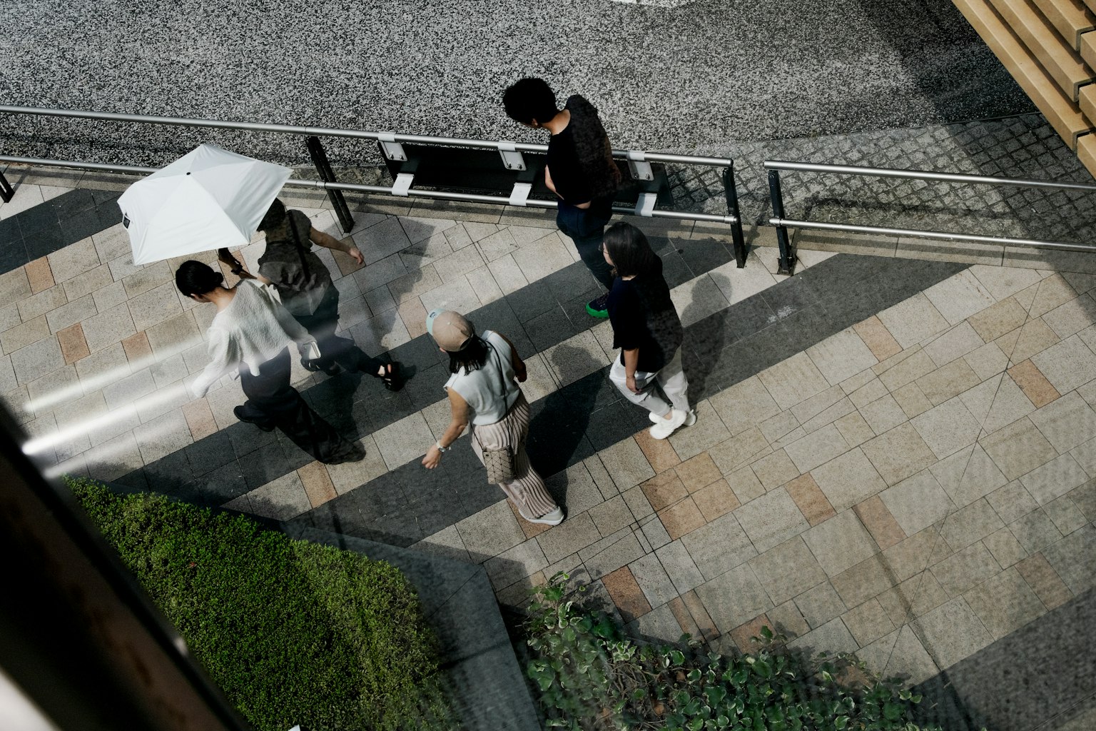 ผู้คนเดินอยู่ในถนนพร้อมกับร่ม