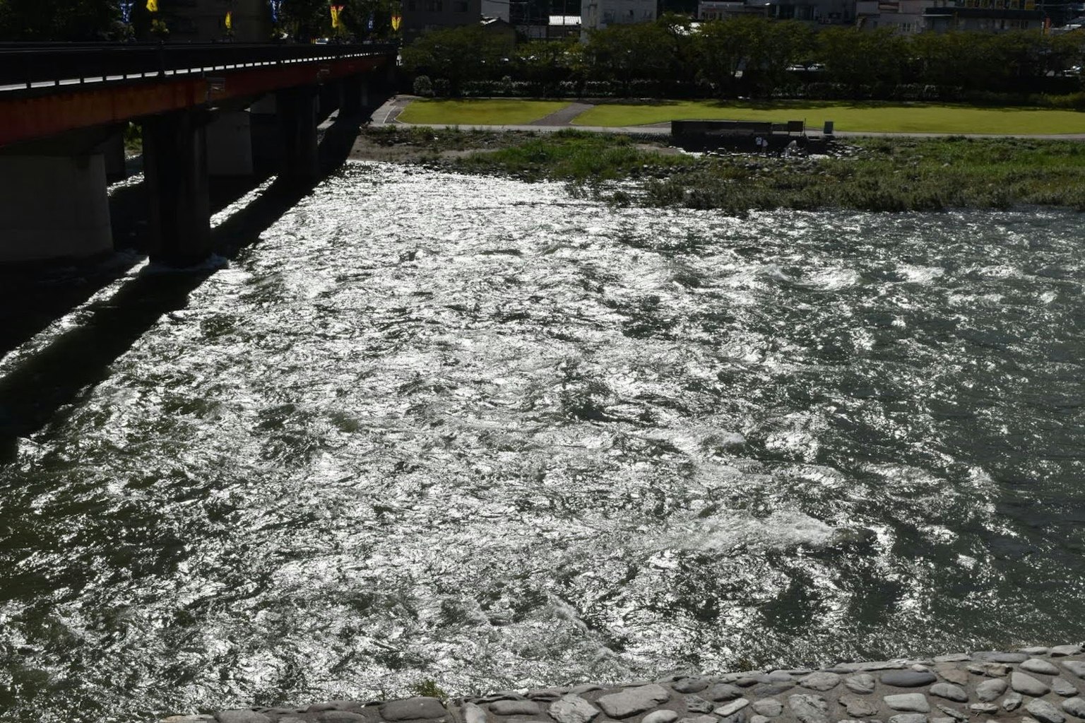 Superficie del río reflectante con parte de un puente