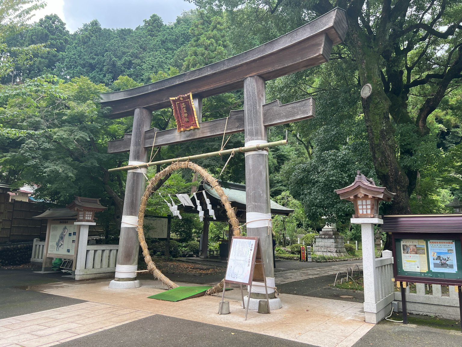 A torii gate and large sacred ring in a lush green landscape