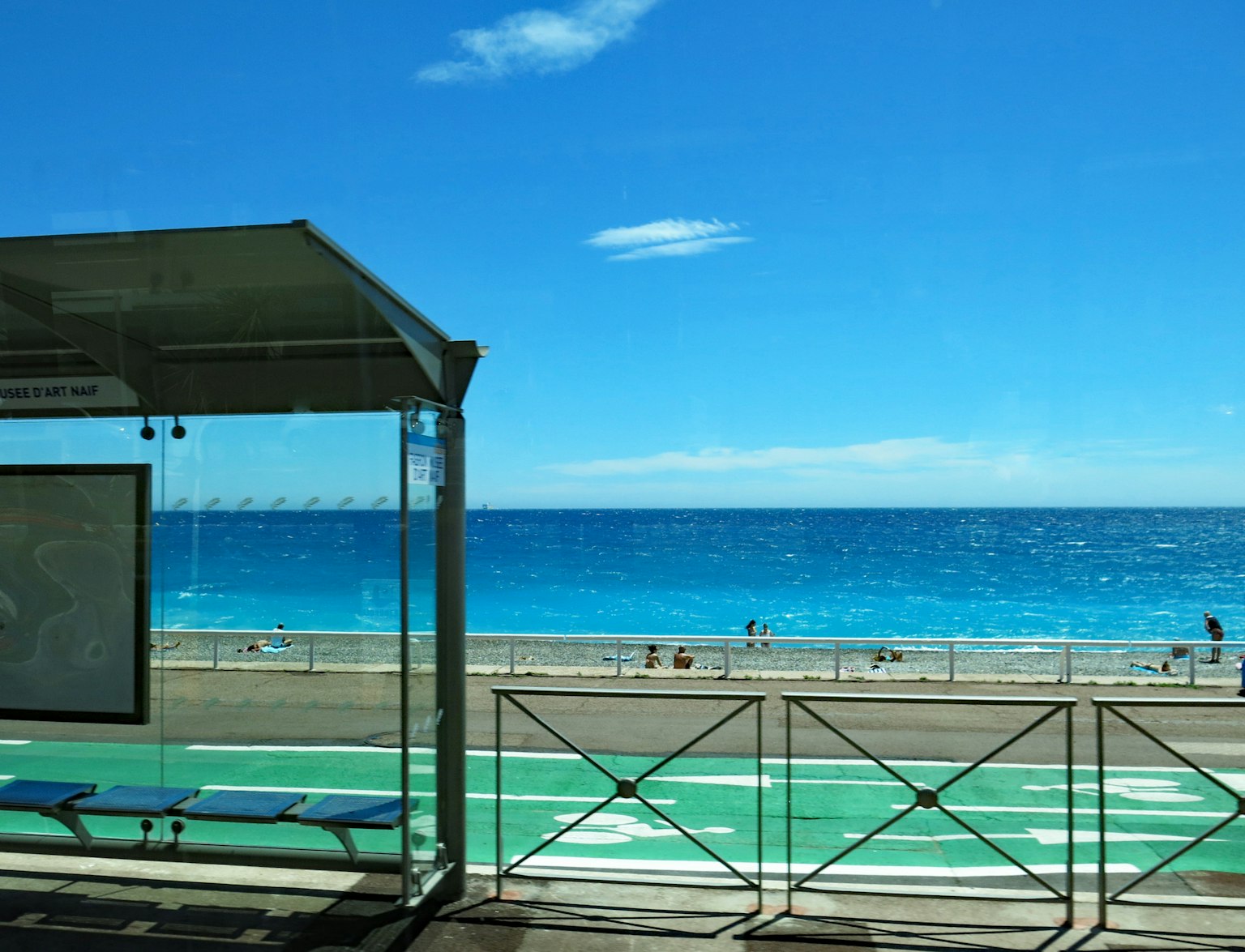 海灘景色，藍色海洋和晴朗天空，顯示巴士站和自行車道