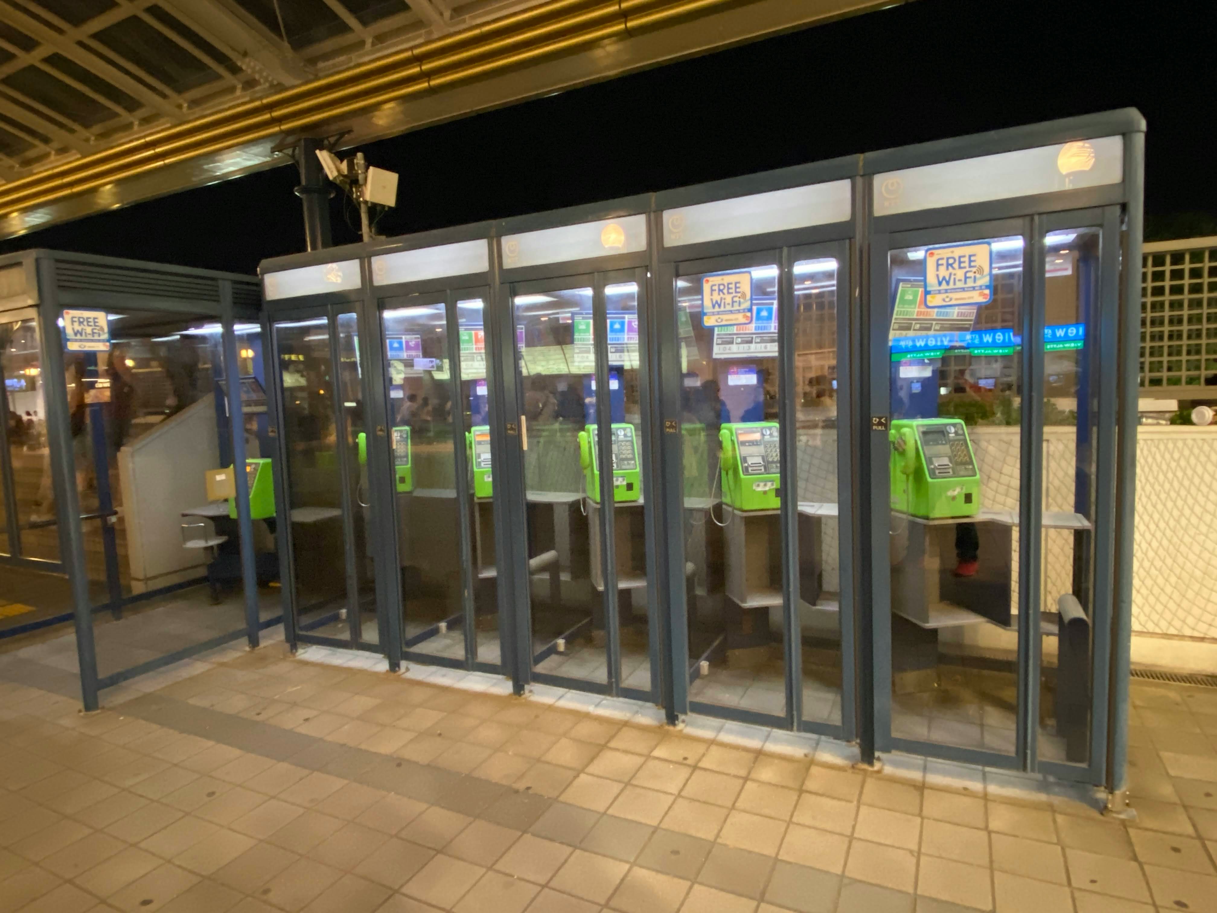 夜の駅の改札口前に並ぶ自動券売機