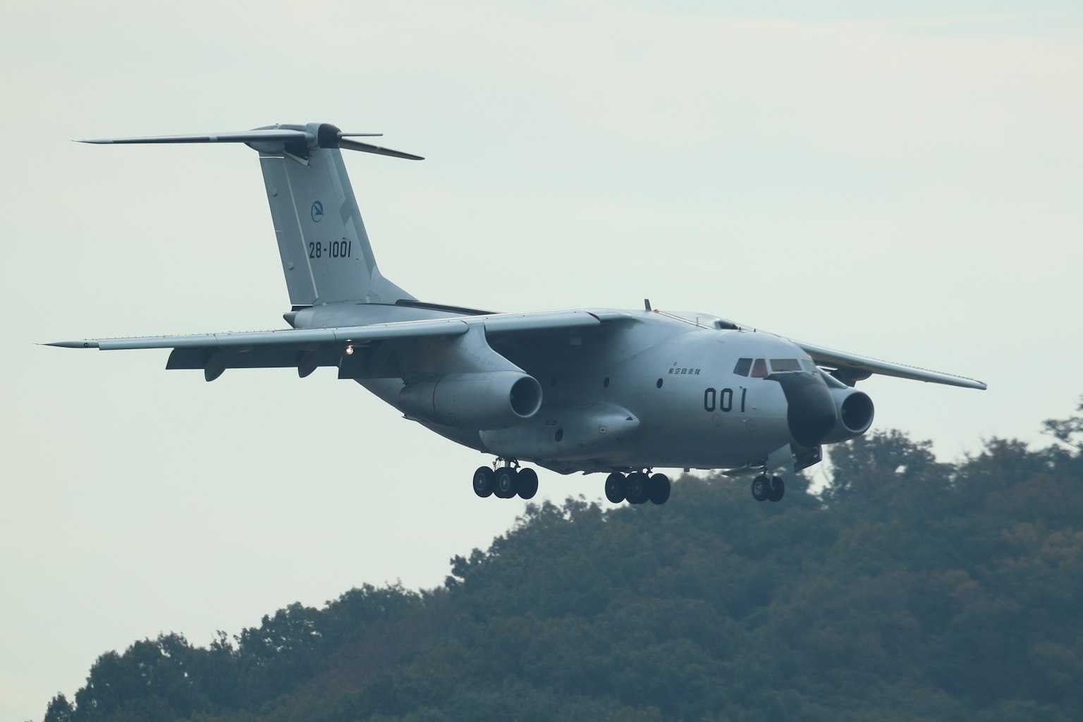 Avión militar volando a baja altura con un fondo montañoso