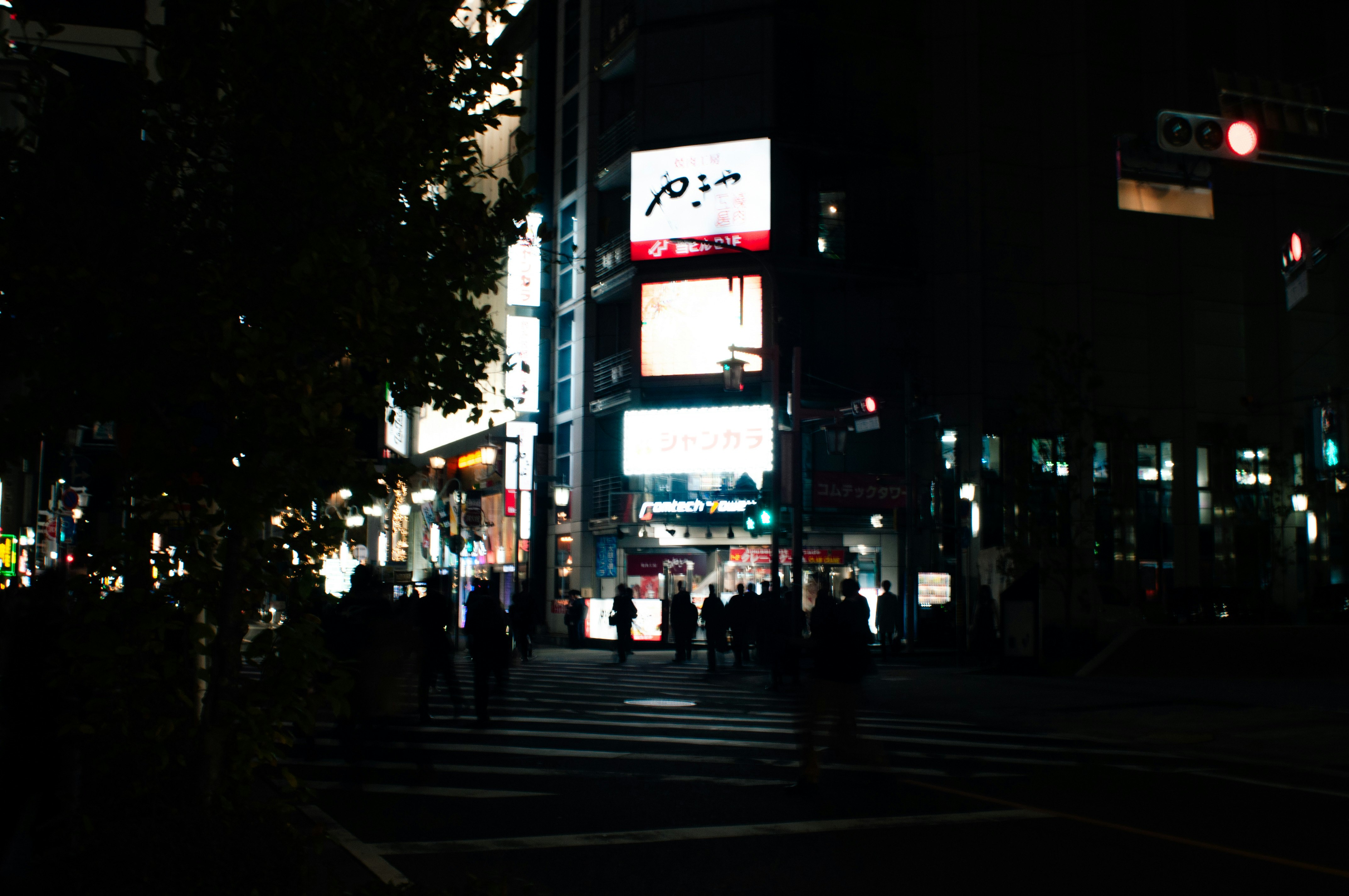 nighttime street scene with neon signs lining the road