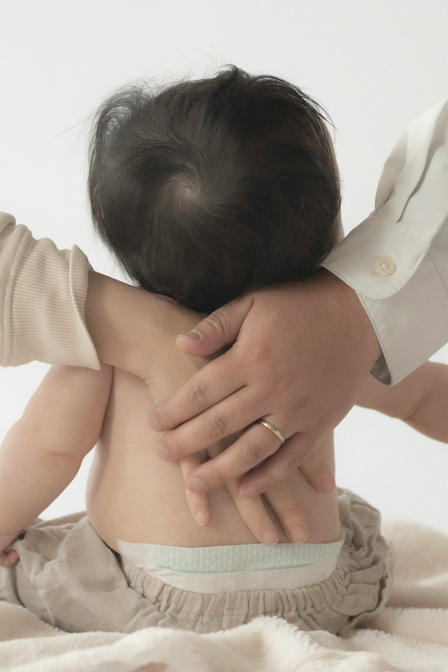 Photo d'une main soutenant doucement le dos d'un bébé