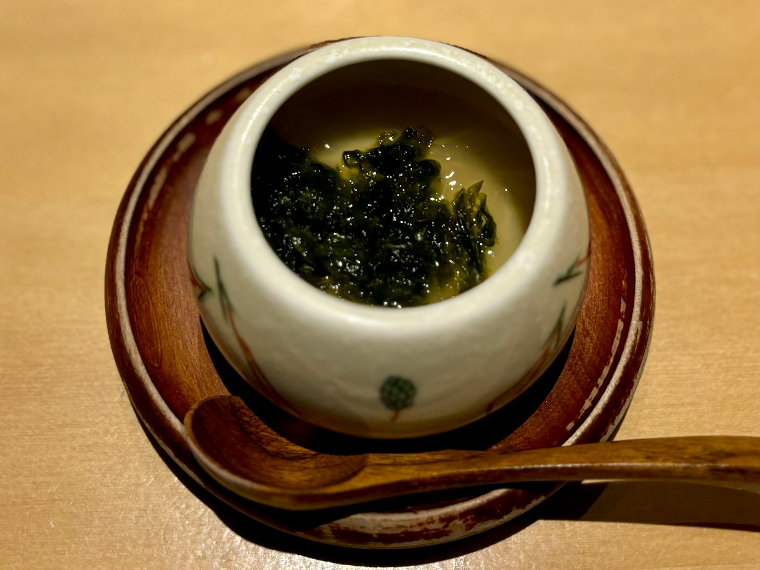 小陶碗盛着海藻菜肴和木勺