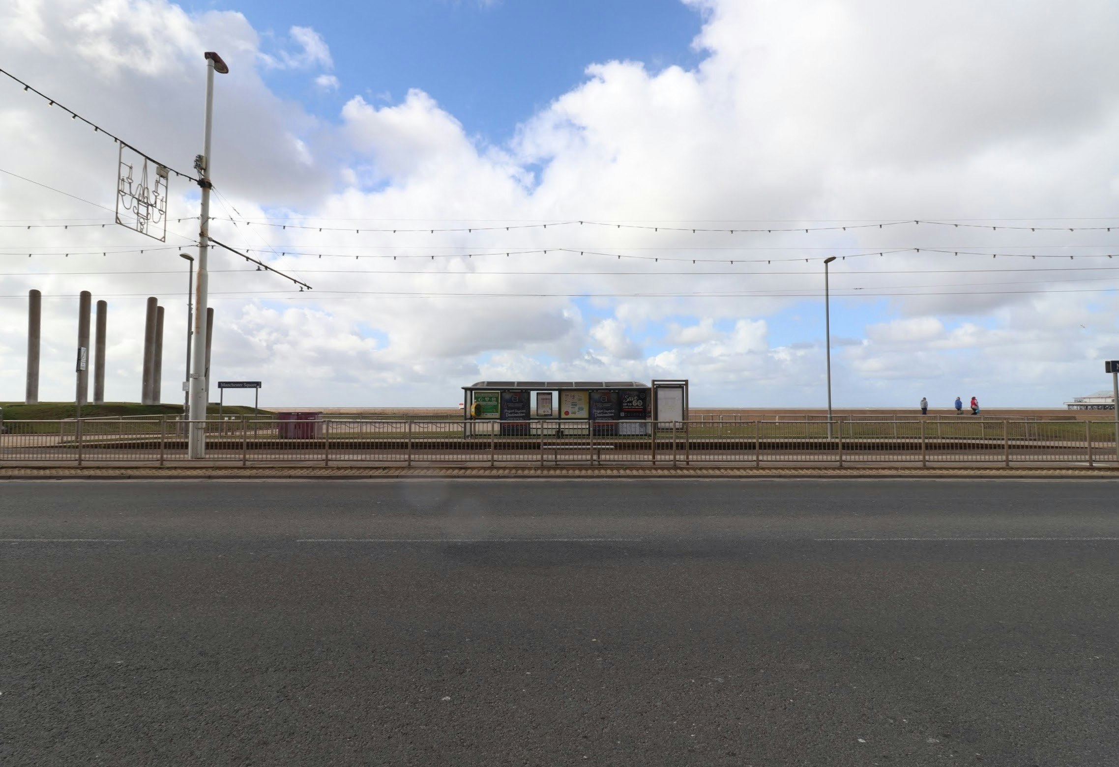 elevated railway tracks and platform under a cloudy sky
