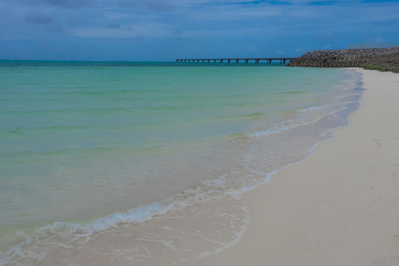 Pemandangan pantai dengan air biru jernih dan pasir putih