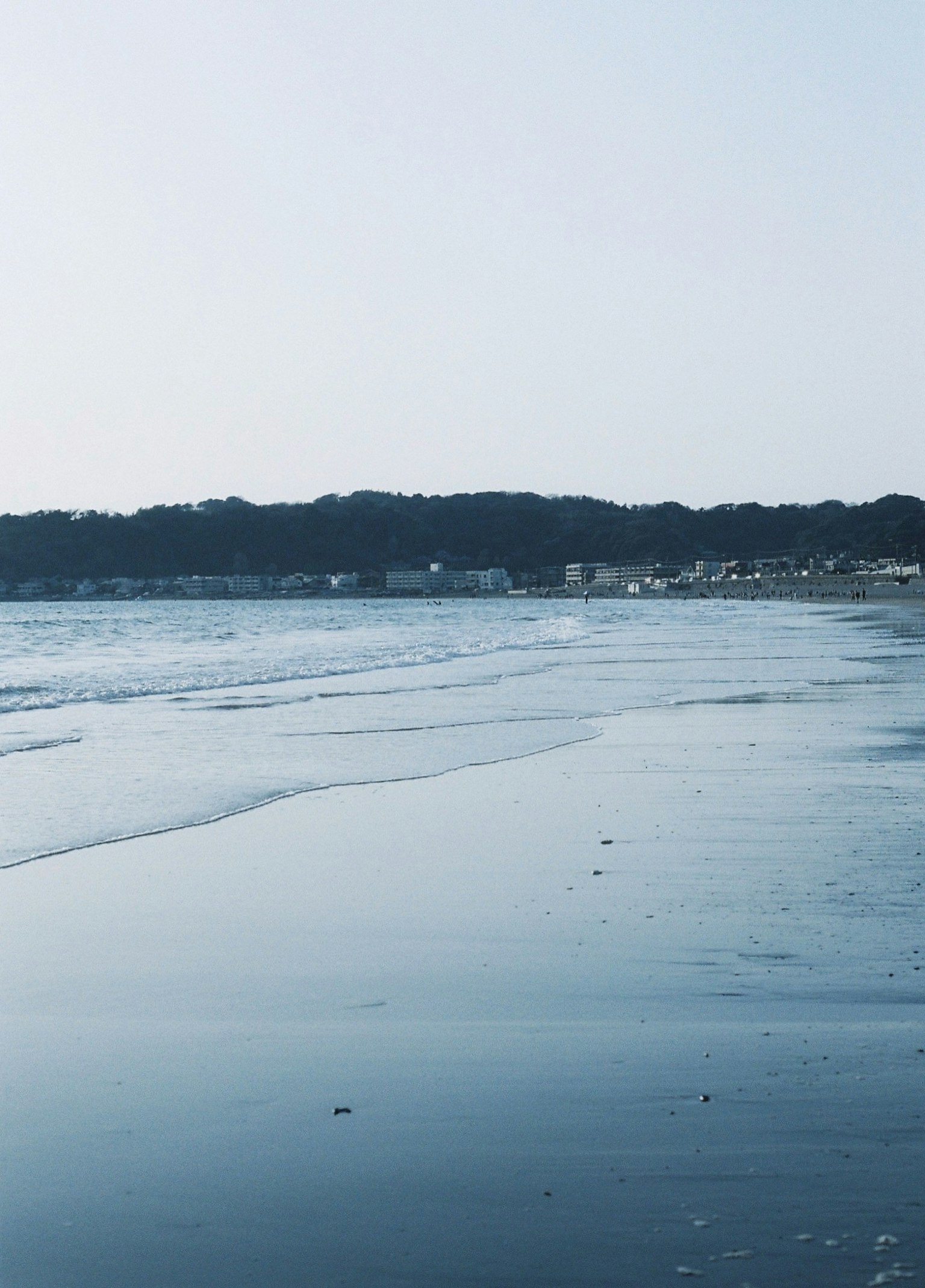 ทิวทัศน์ชายหาดที่สงบฟ้าสีฟ้าและคลื่นที่ซัดเข้าหาชายฝั่ง