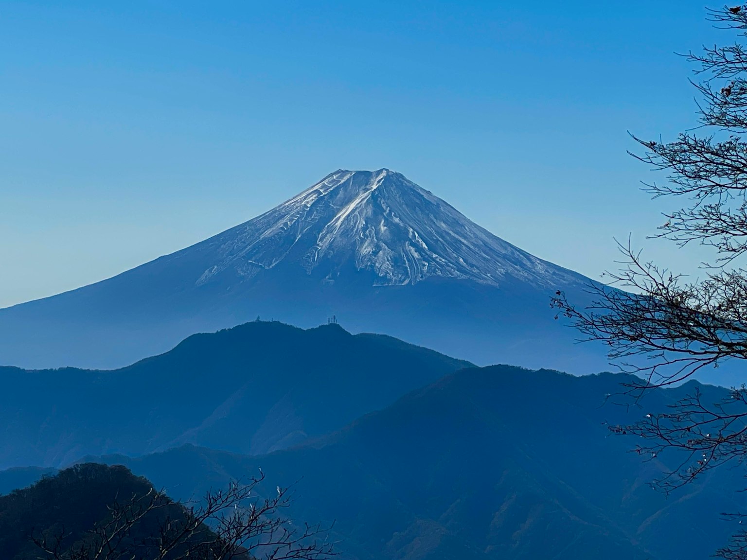 Vista spettacolare del monte Fuji innevato contro un cielo blu chiaro