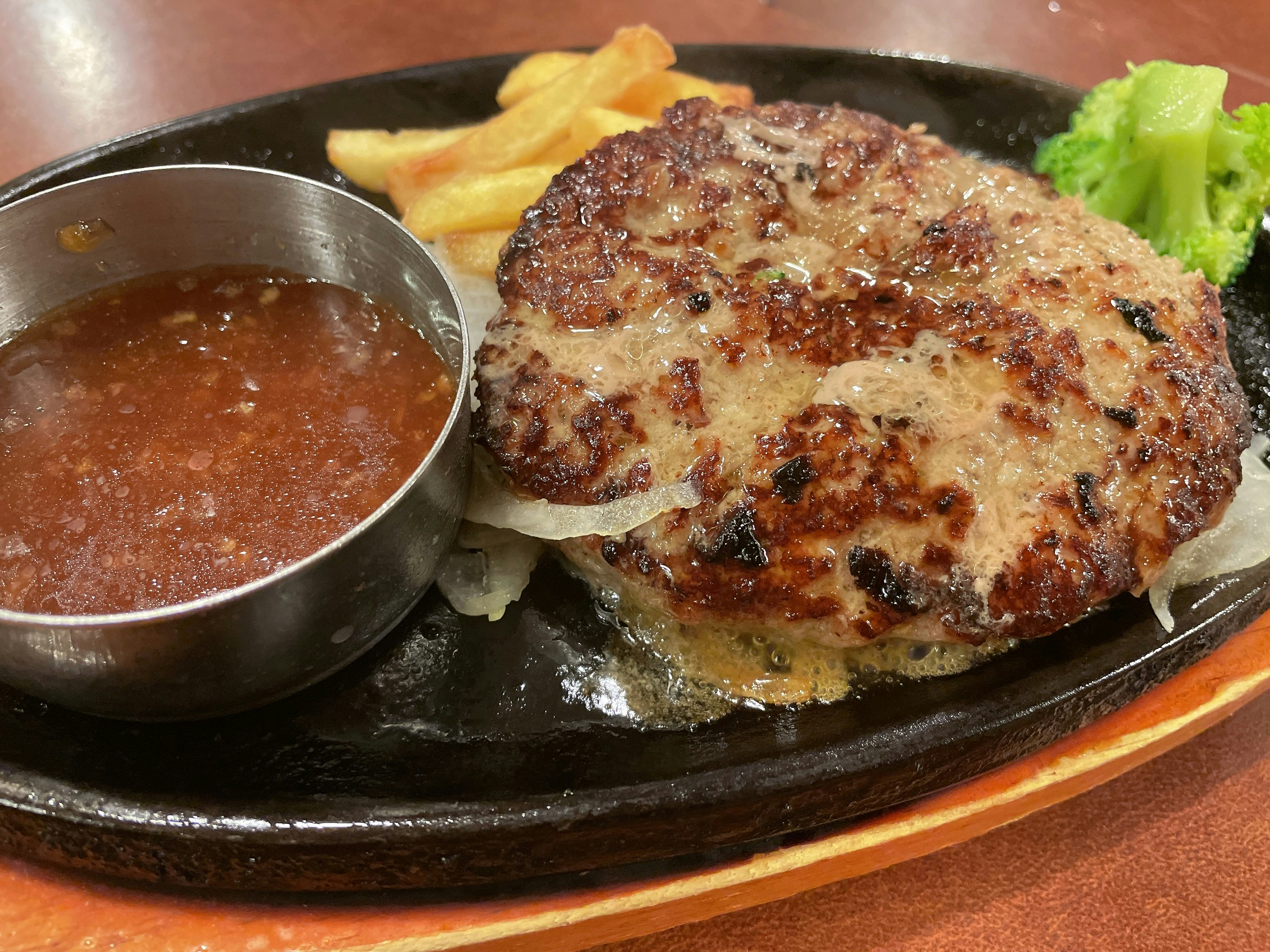鉄板で焼いたハンバーグとソース、付け合わせ