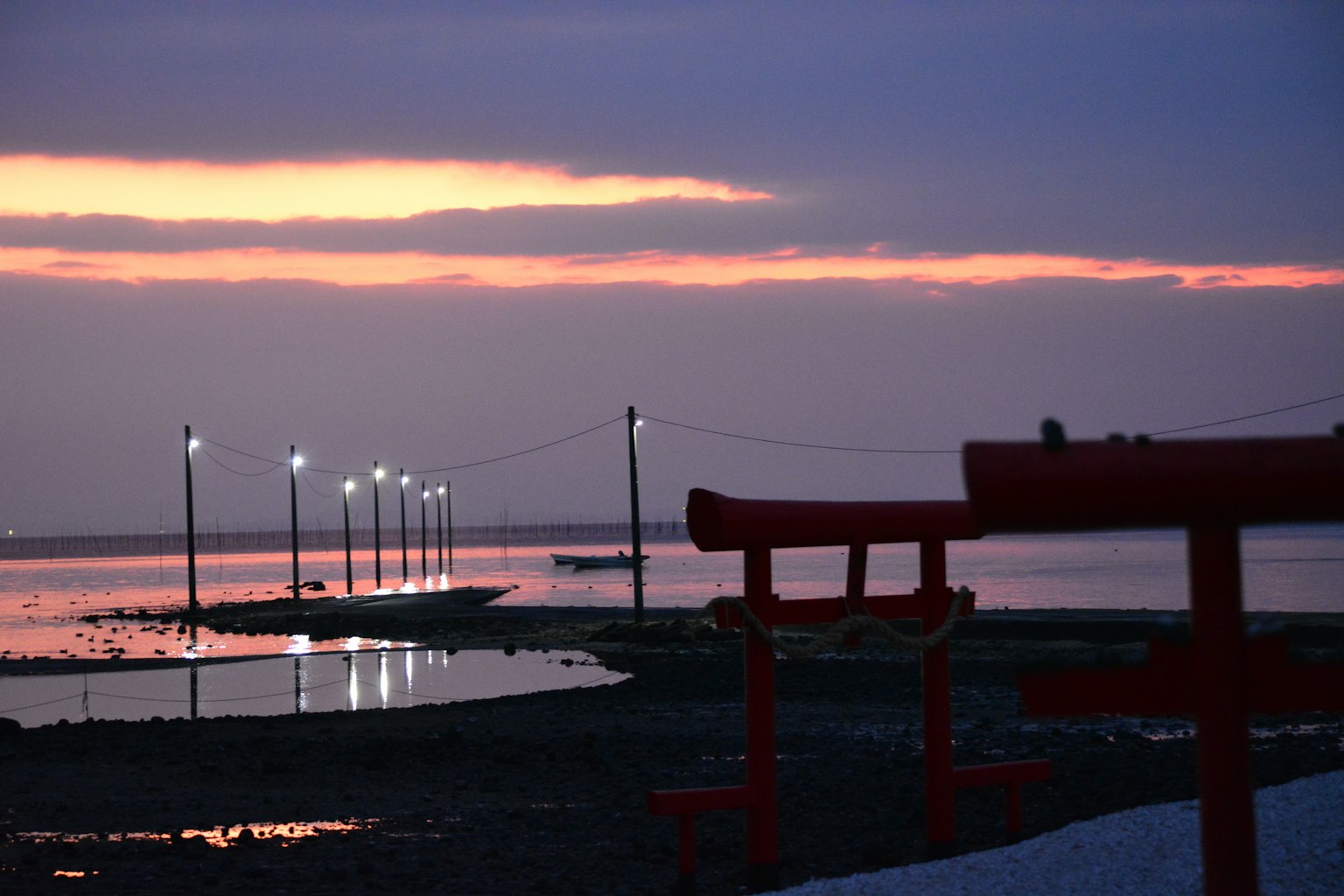 夕陽下的海岸景色與鳥居和燈光