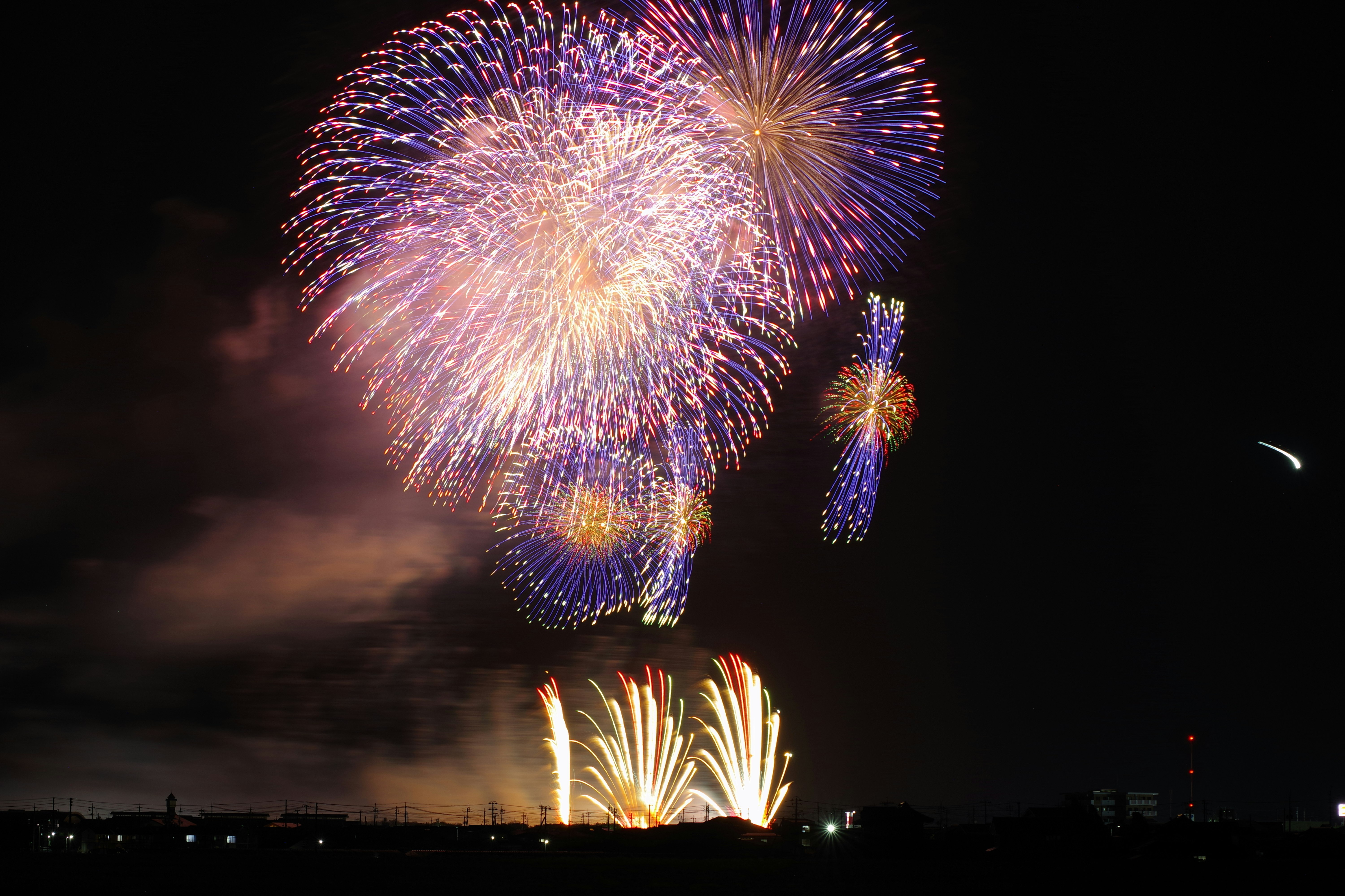 夜空に咲く花火と打ち上げ花火の光景
