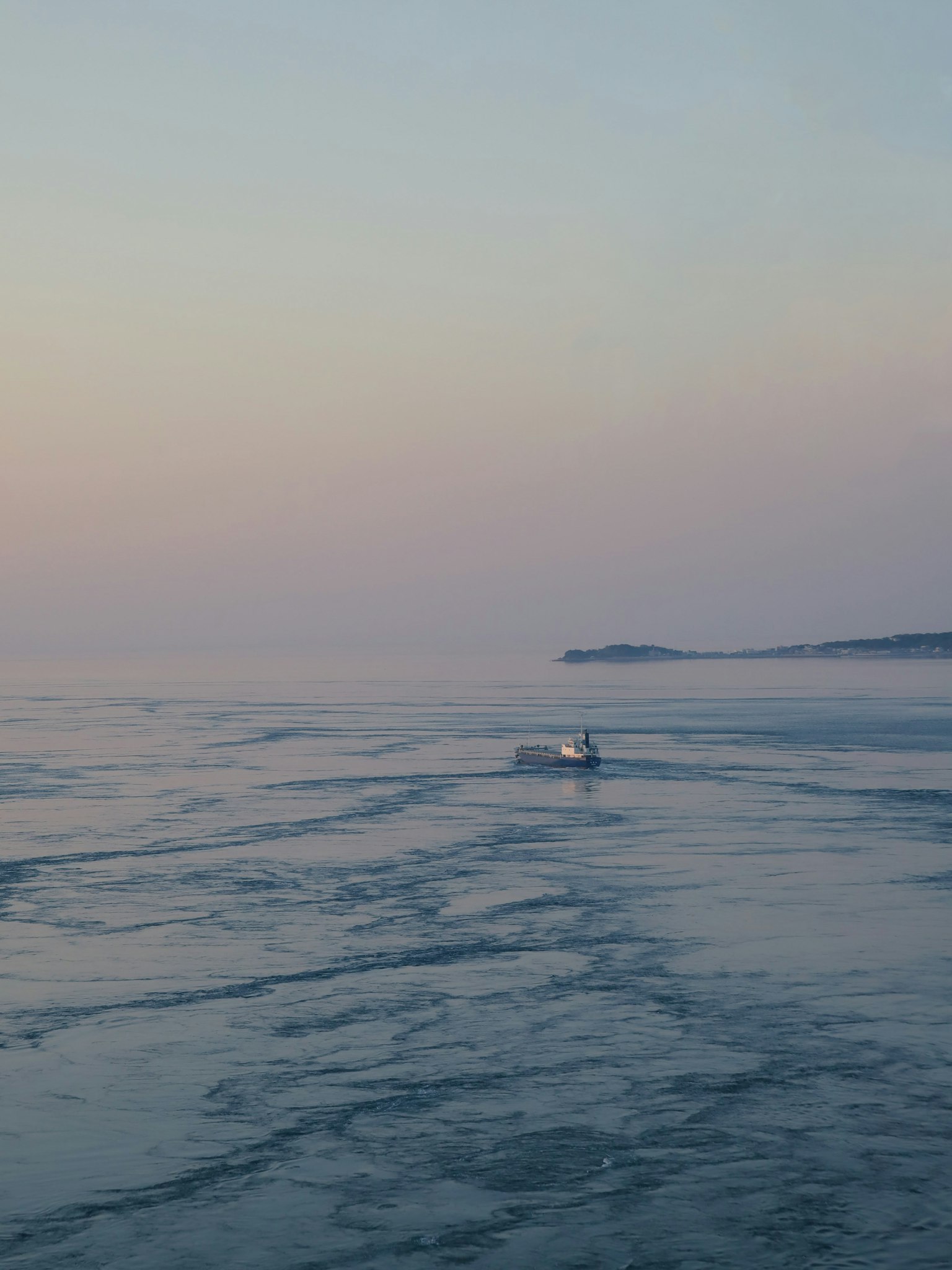 Una piccola barca che galleggia su un mare calmo durante il crepuscolo