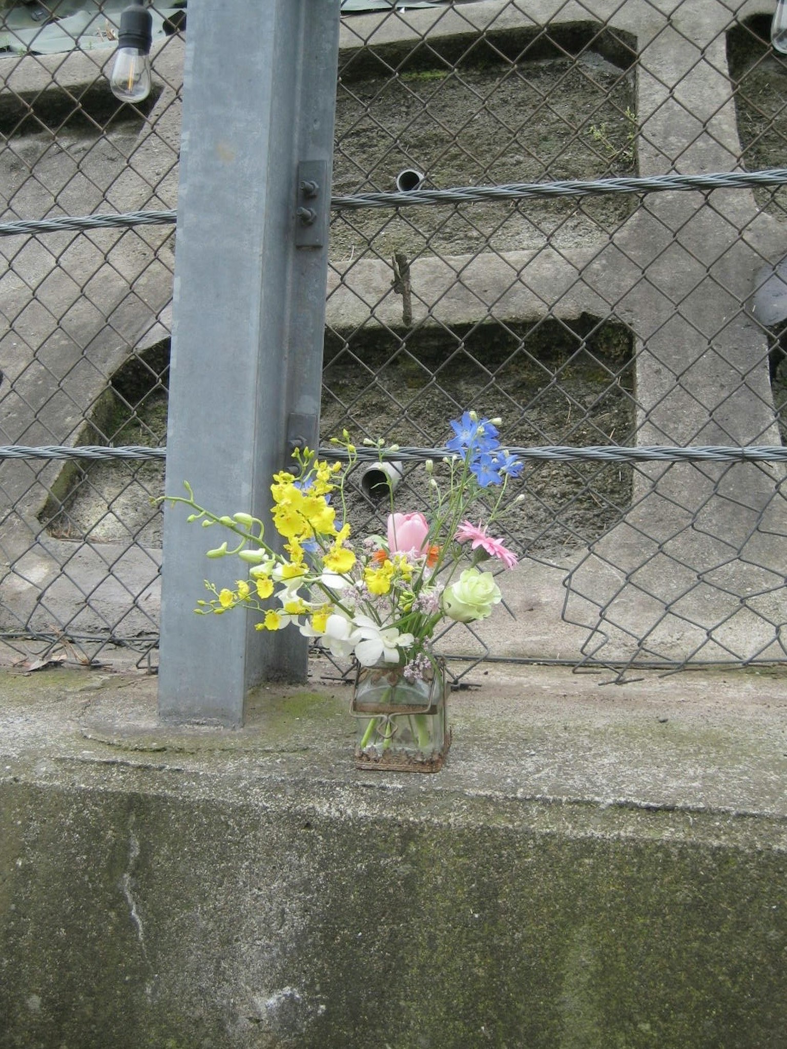 A bouquet of flowers placed near a fence