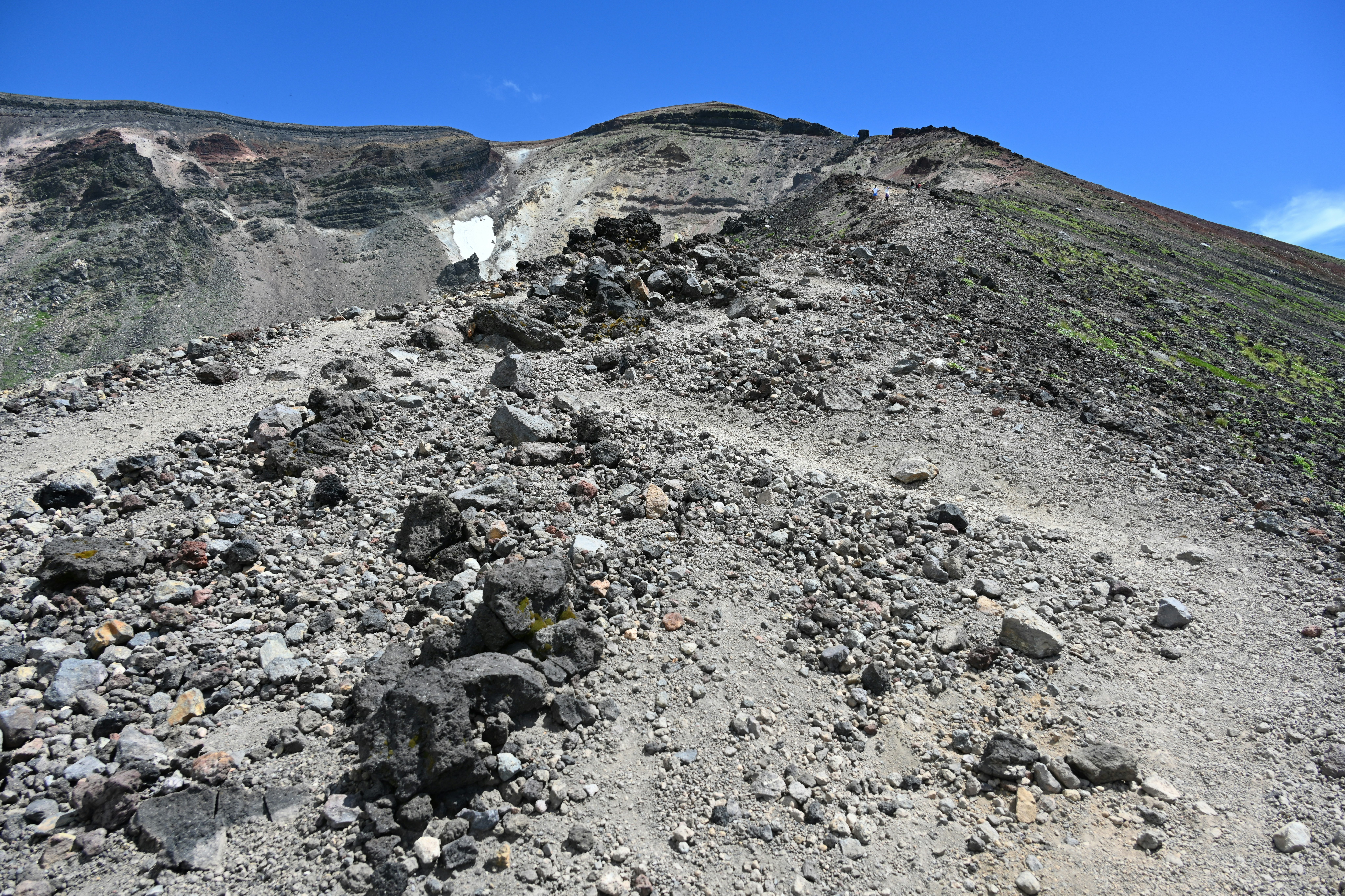 rocky volcanic crater slope and ash-strewn ground