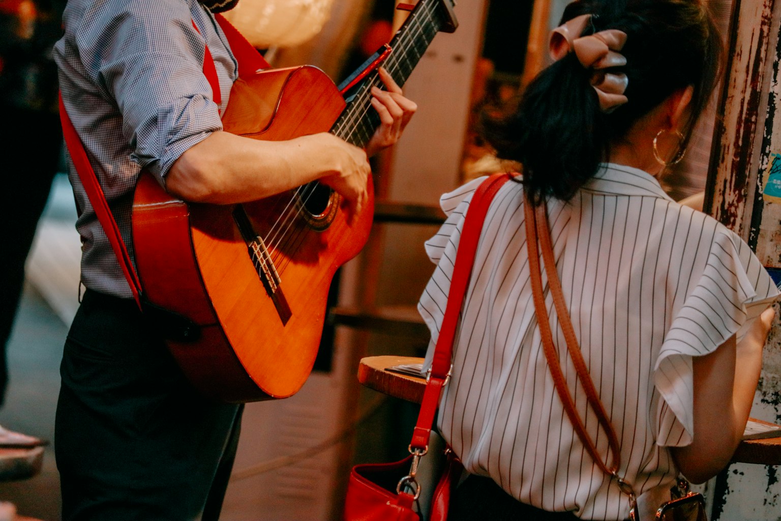Un homme jouant de la guitare et une femme en tenue décontractée de dos