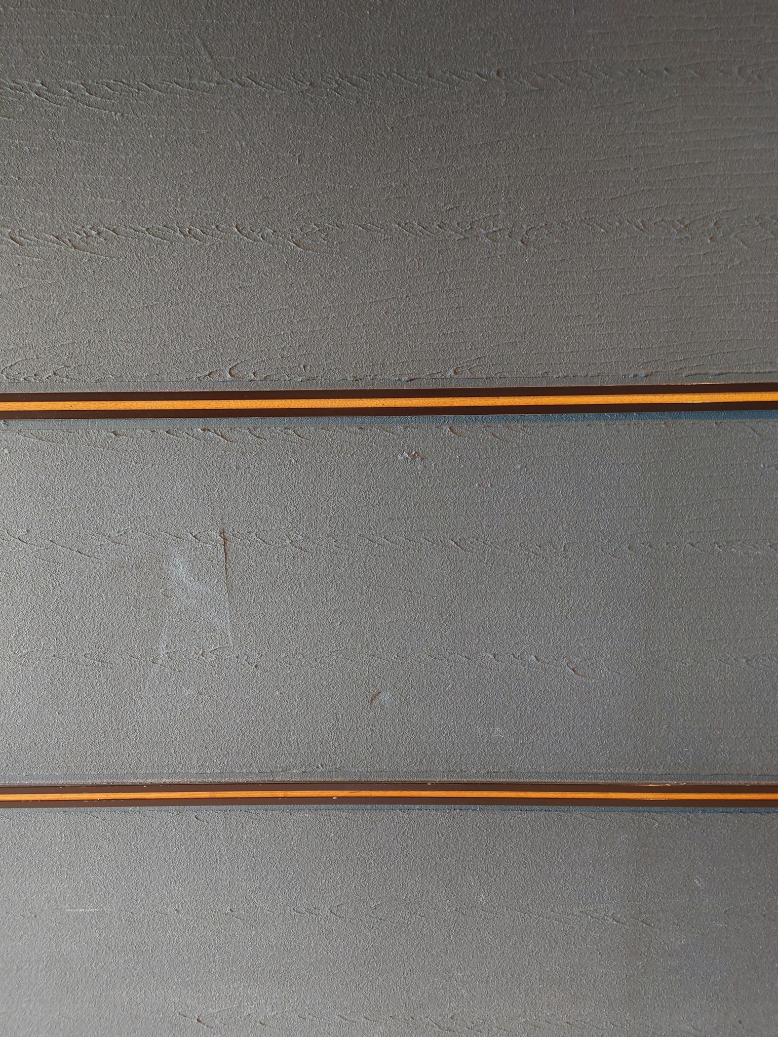 Dos líneas naranjas a lo largo de una pared gris