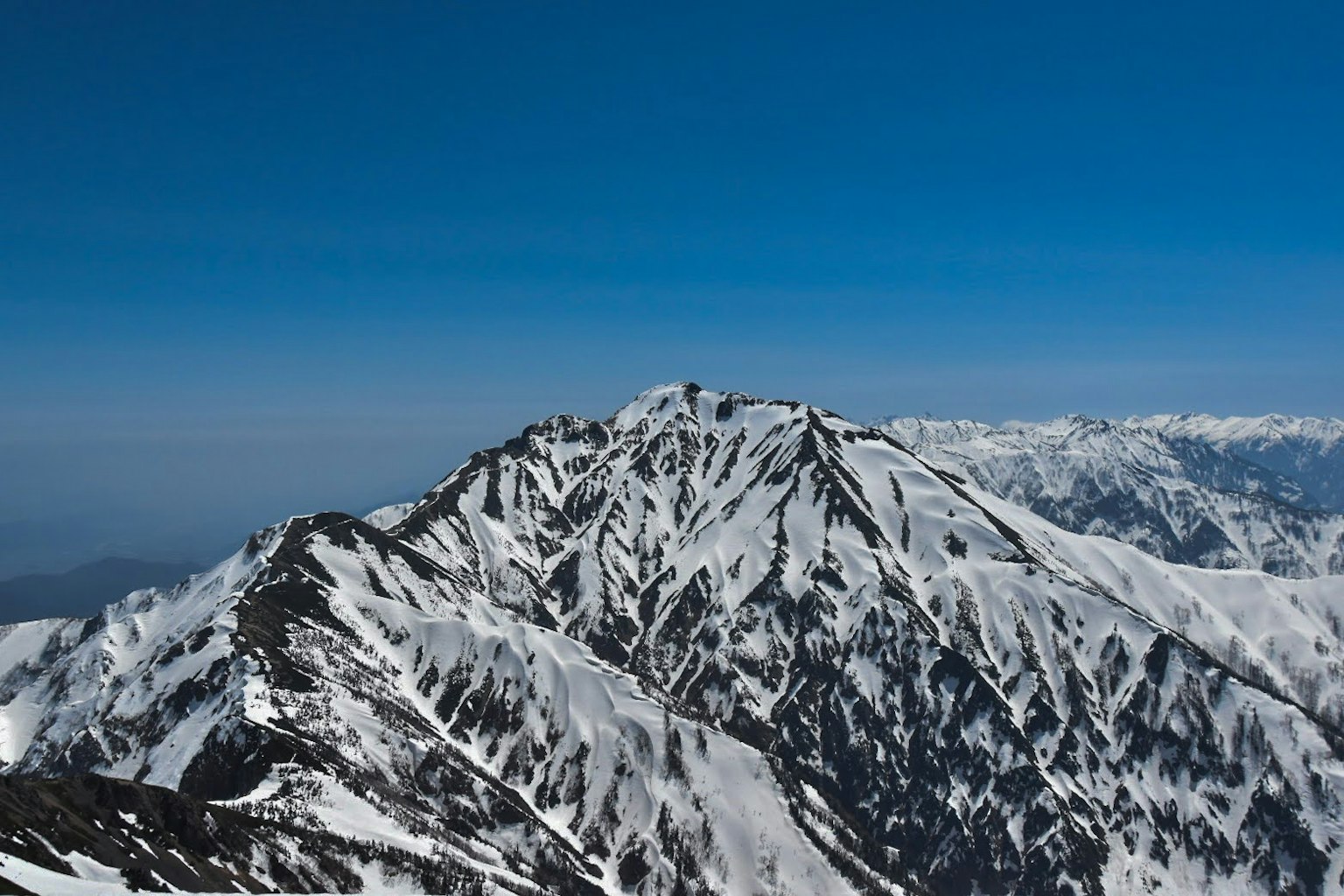Schneebedeckte Berglandschaft unter blauem Himmel