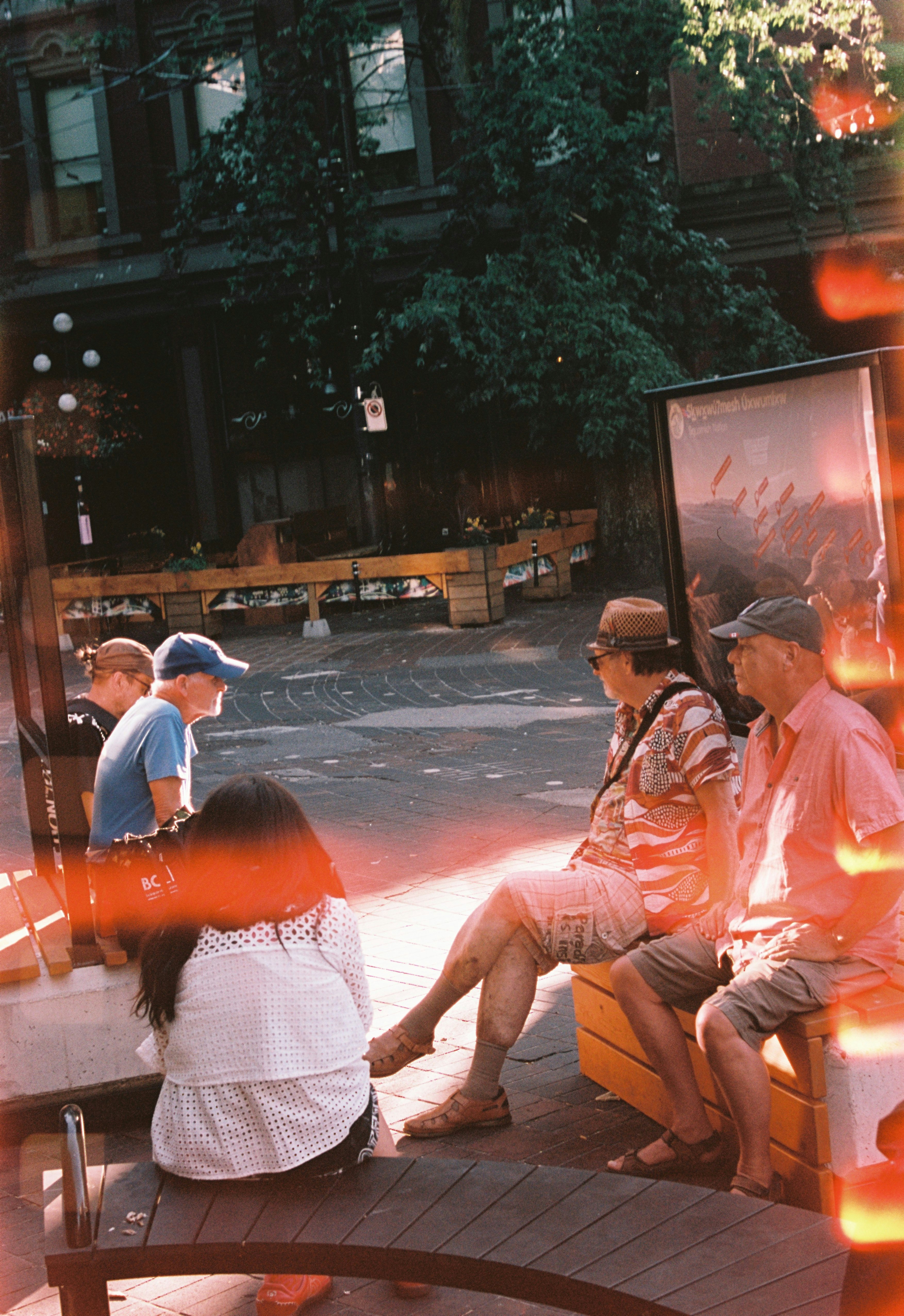 夜の街角でベンチに座る人々のフィルム風スナップ