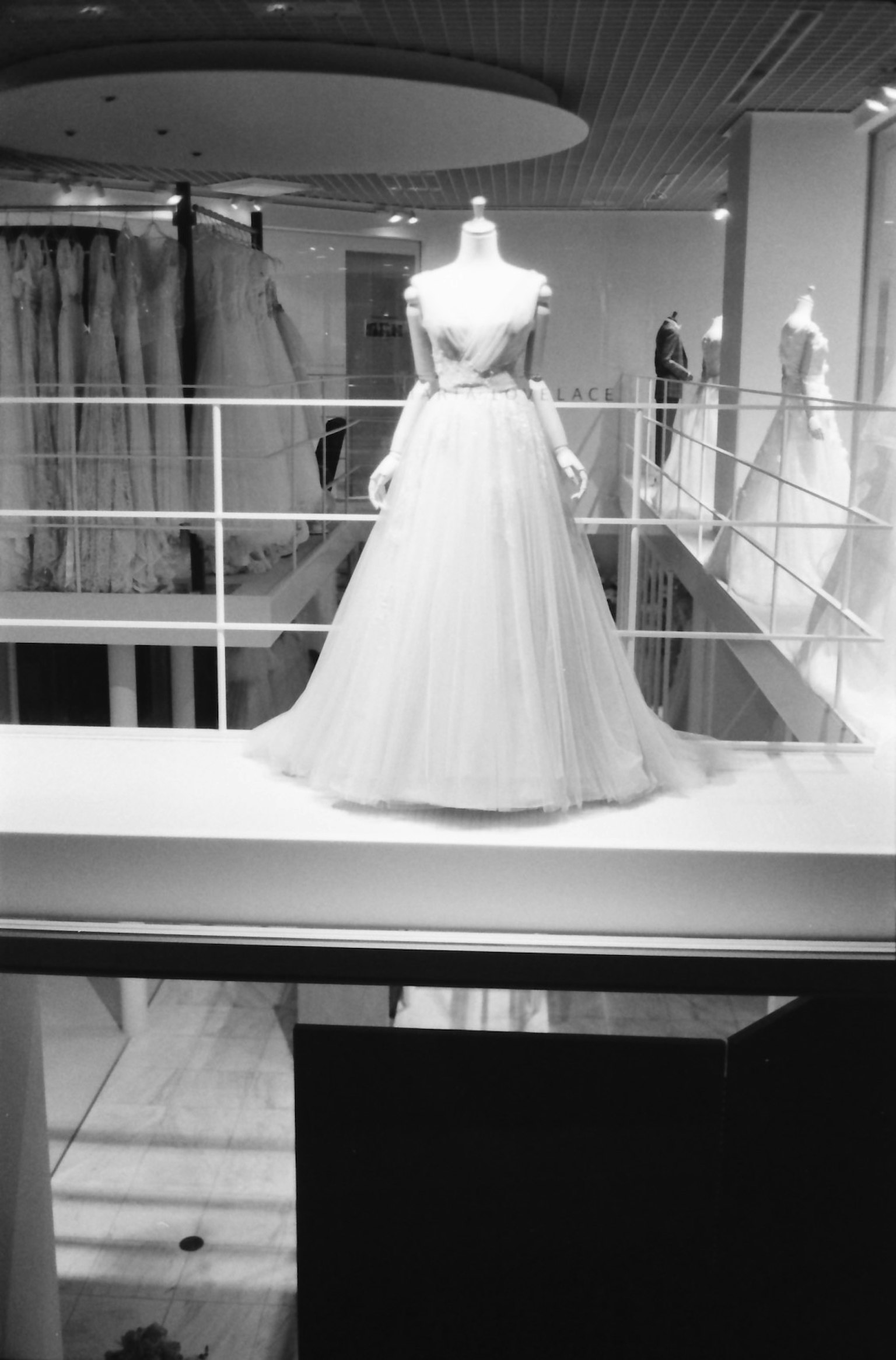 A mannequin displaying a white dress in a fashion studio interior