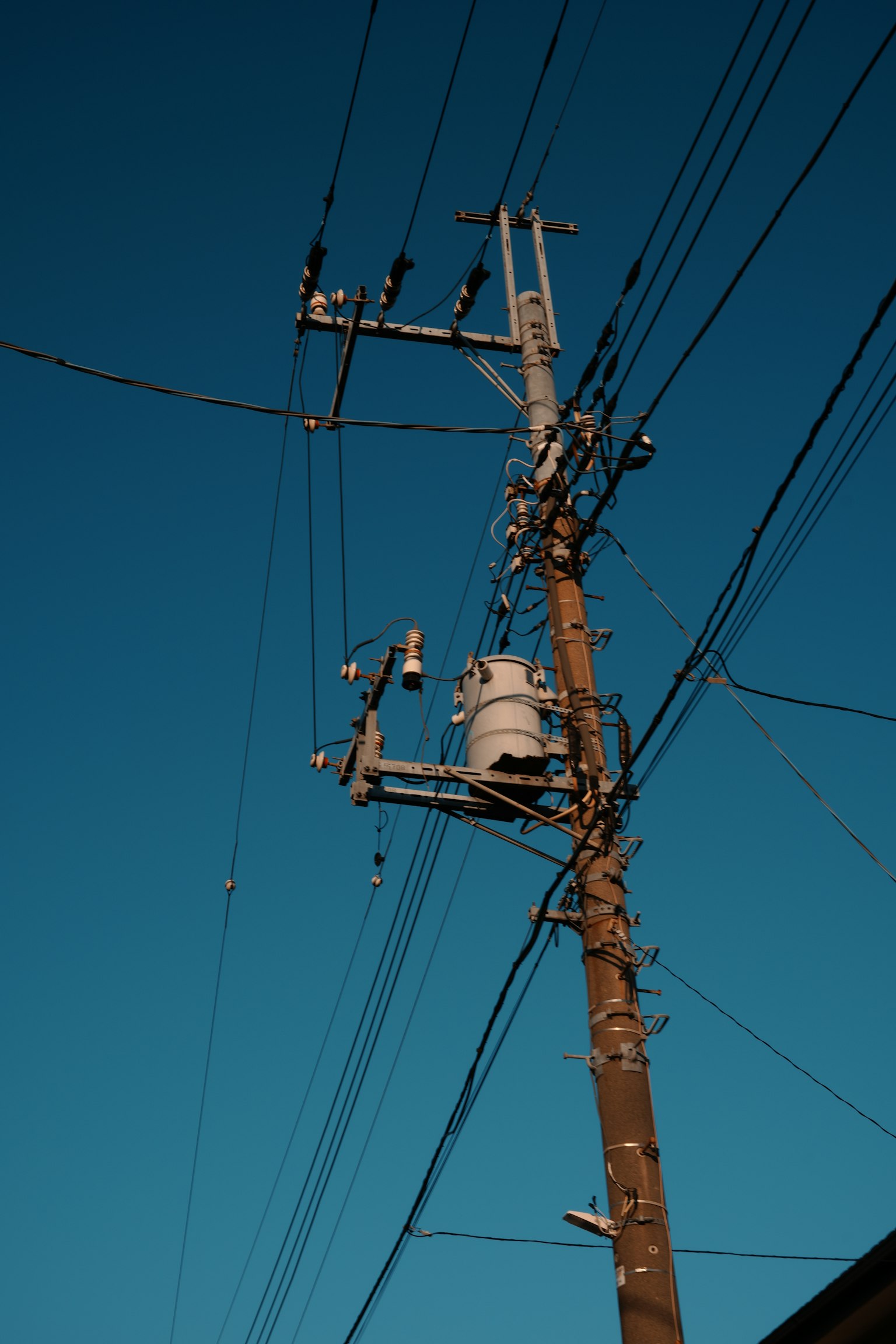 Power pole and wires against a blue sky