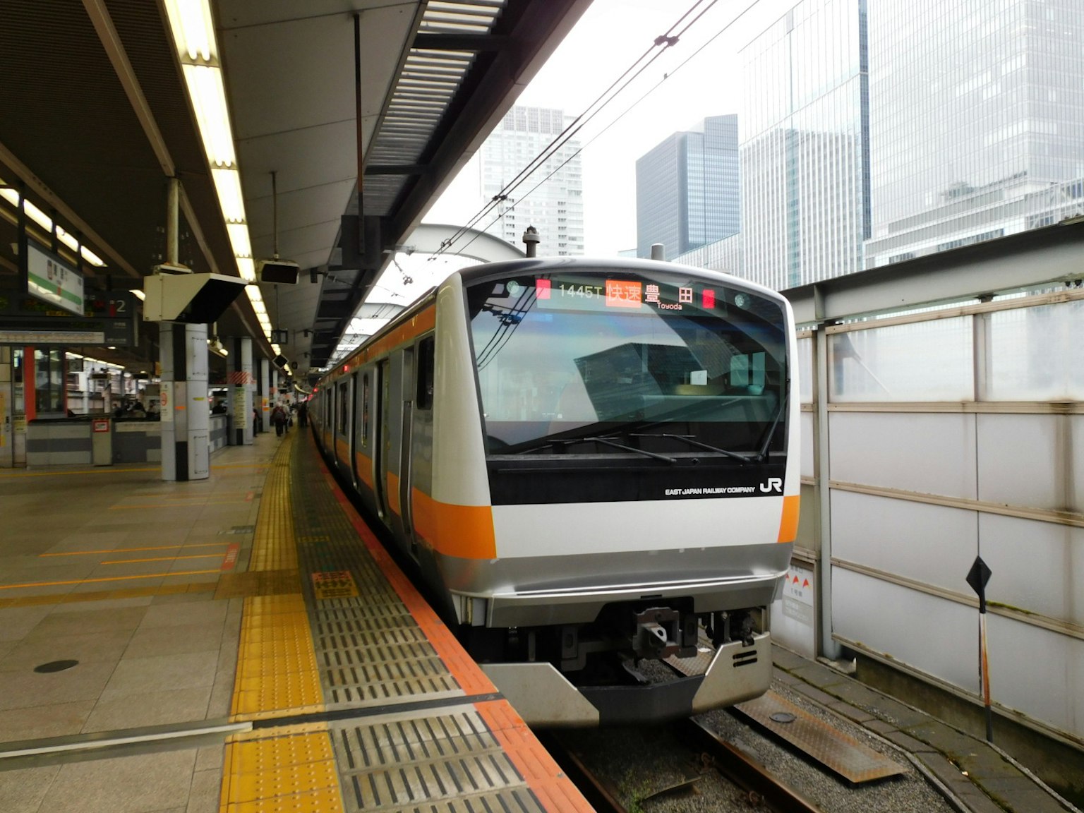 帶有橙色條紋的火車停在車站月台