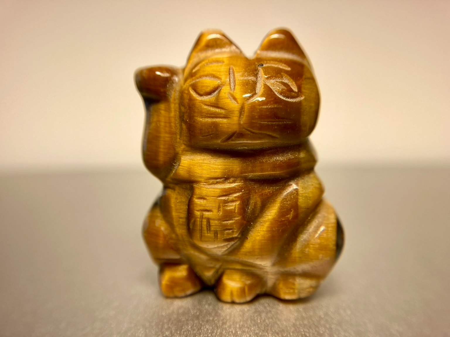 Scultura in legno di un gatto fortunato di colore marrone seduto