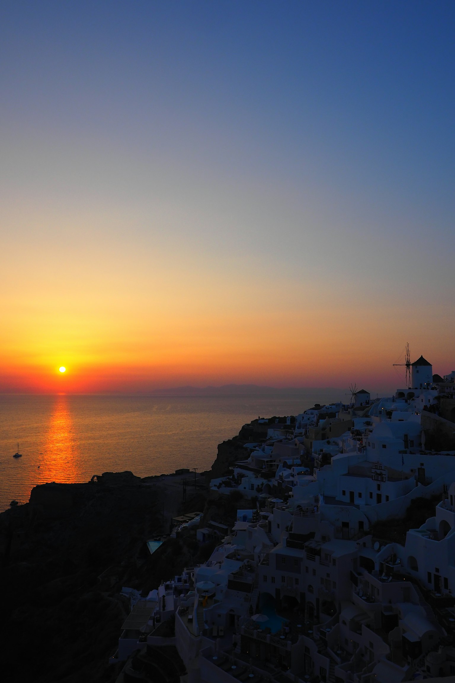Schöne Landschaft von Santorin mit Sonnenuntergang über dem Meer und weißen Gebäuden
