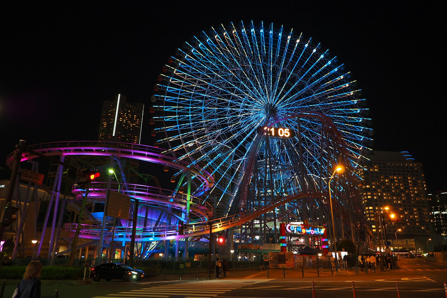 夜晚的摩天轮被蓝色和紫色灯光照亮的场景