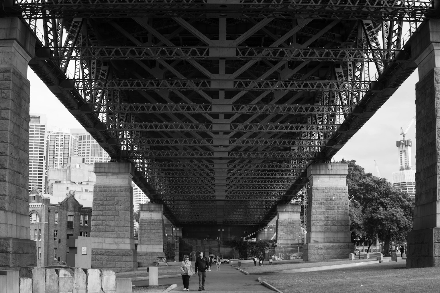 Blick auf eine Stahlbrücke von unten Menschen, die darunter gehen