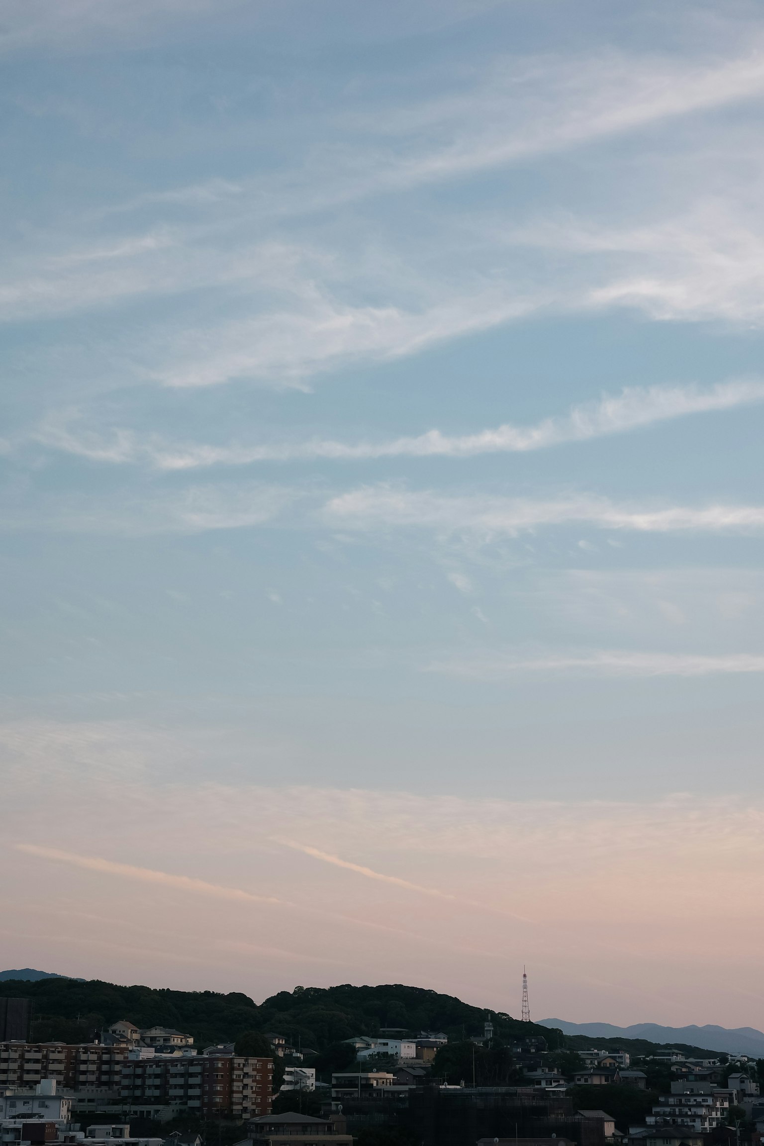 Une vue panoramique du ciel bleu avec des nuages au-dessus des collines et des bâtiments