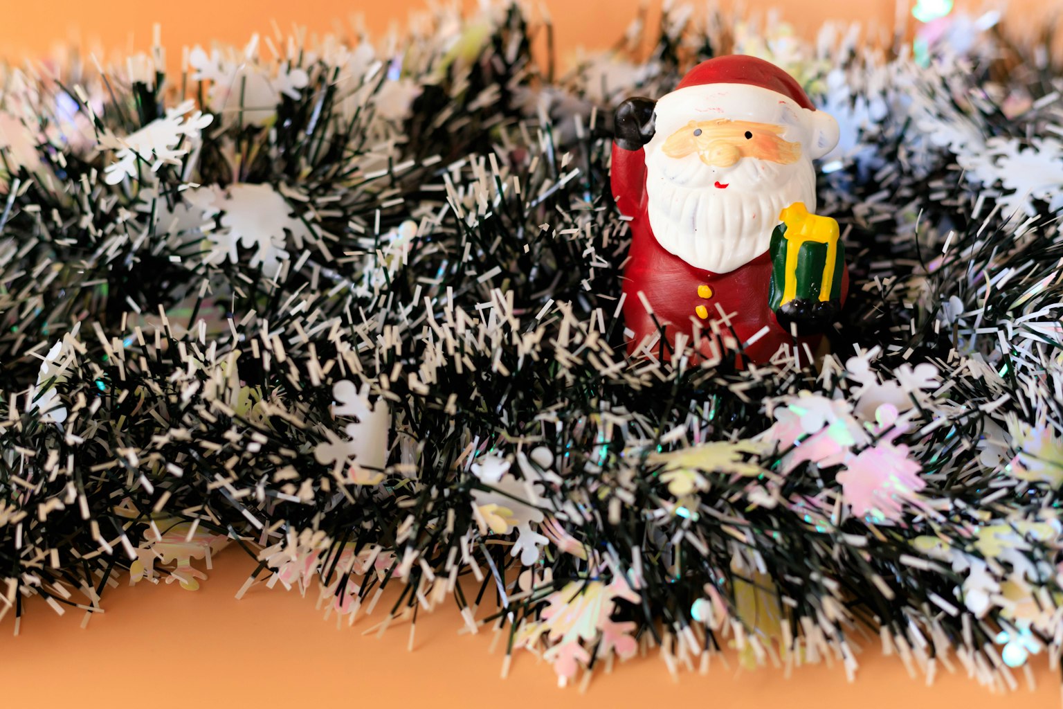 Figura de Santa escondida en una guirnalda de Navidad negra y blanca